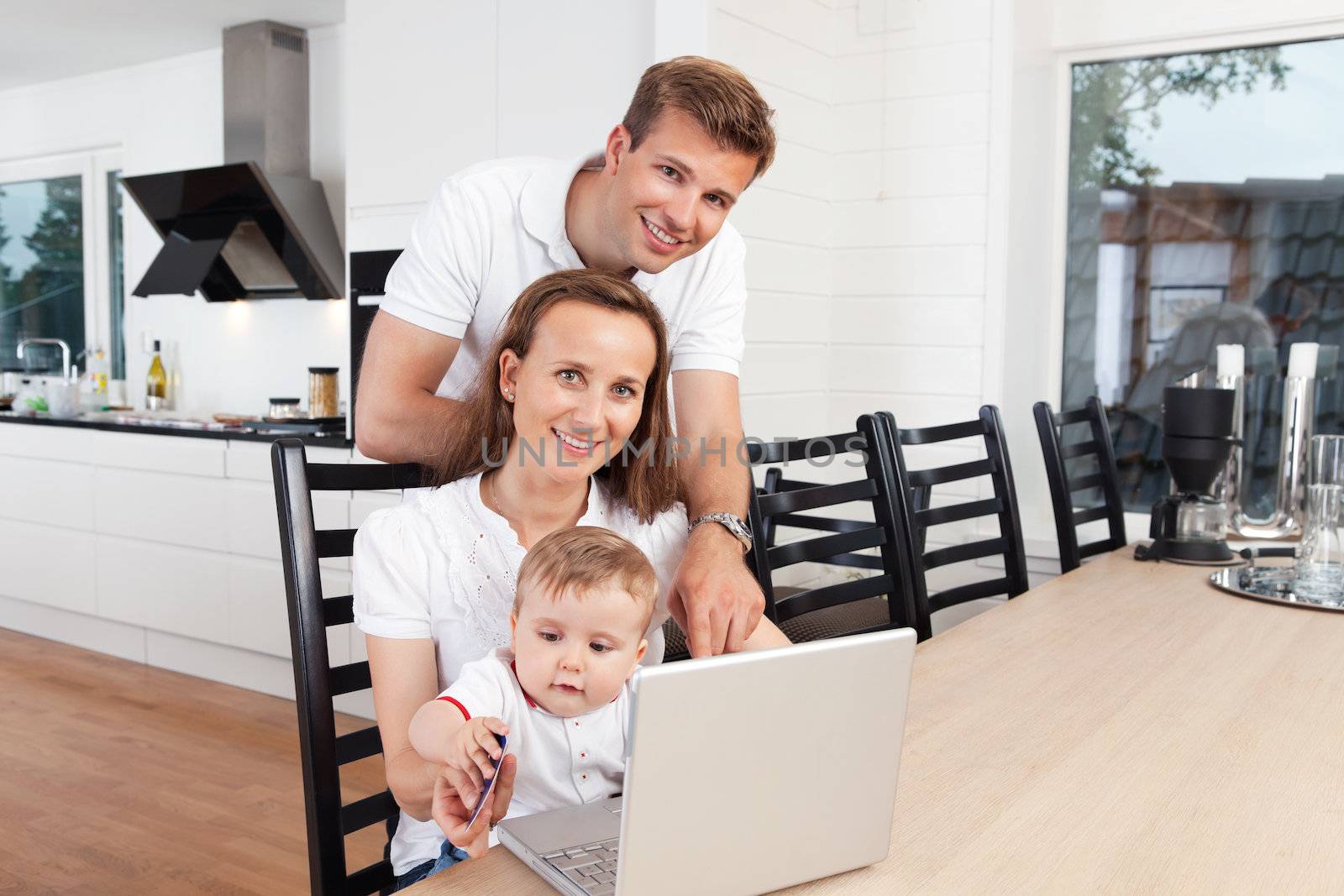 Happy family with laptop by leaf