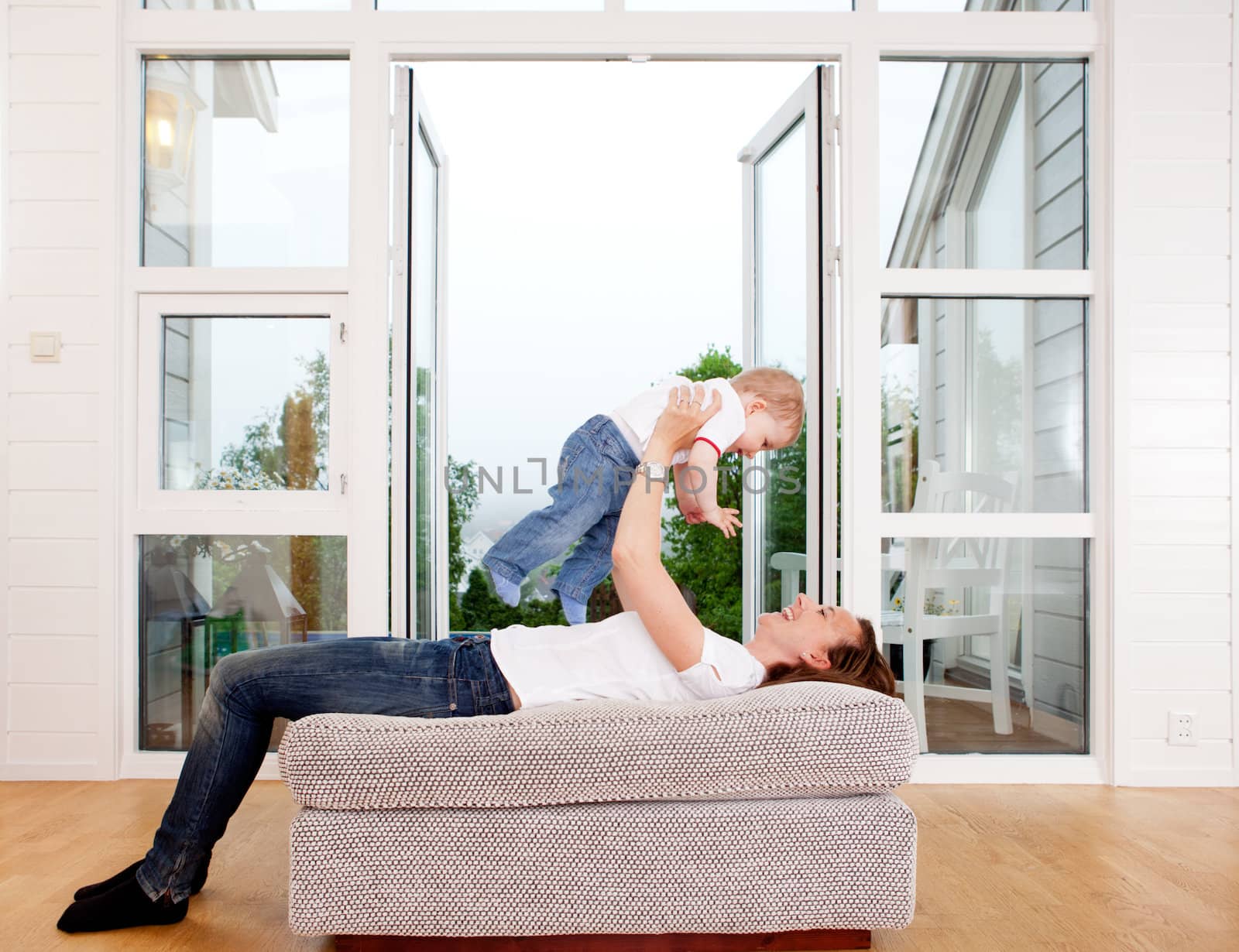 Mother holding son over head playing and having fun at home