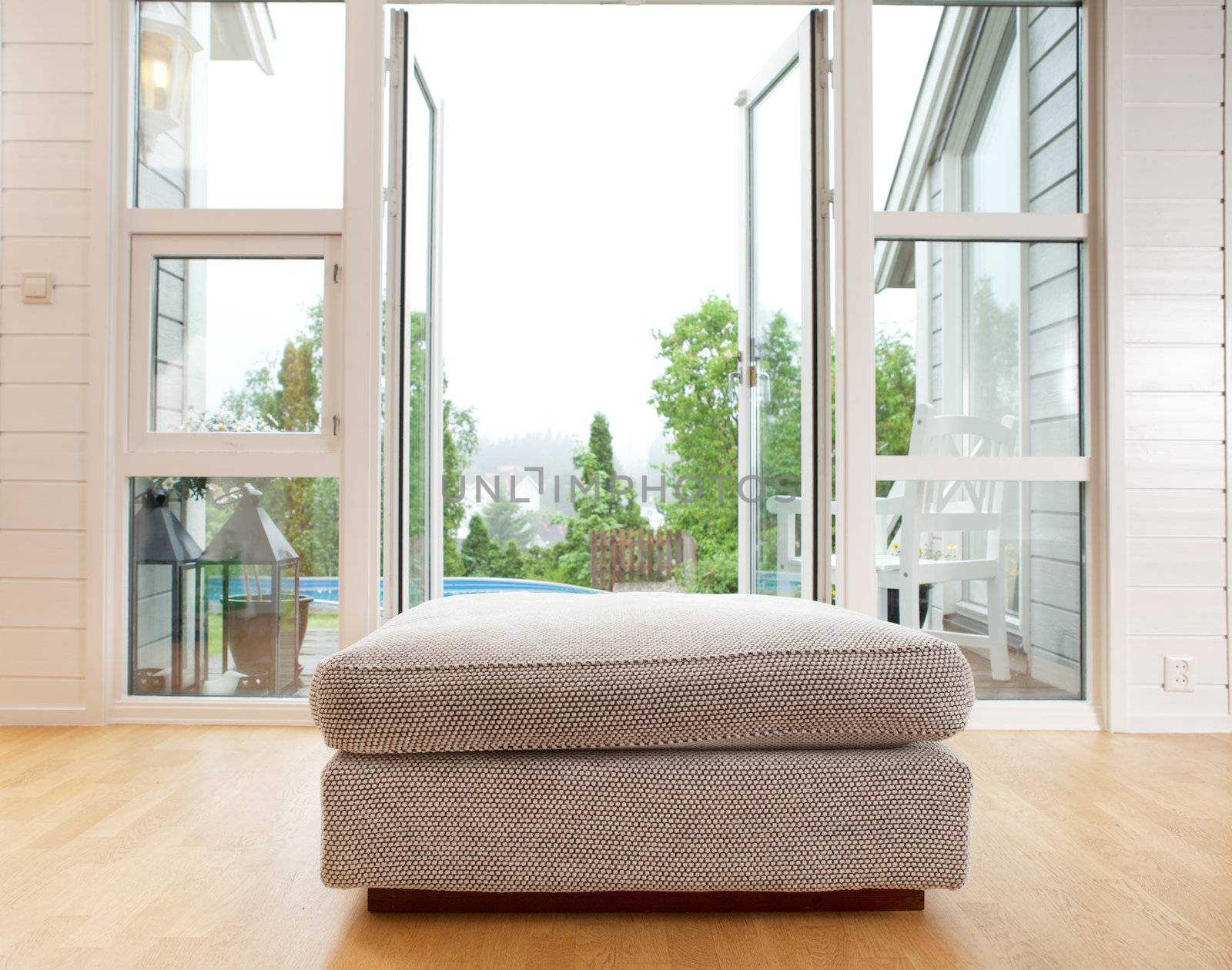 A large chair cushion in front of a large open window