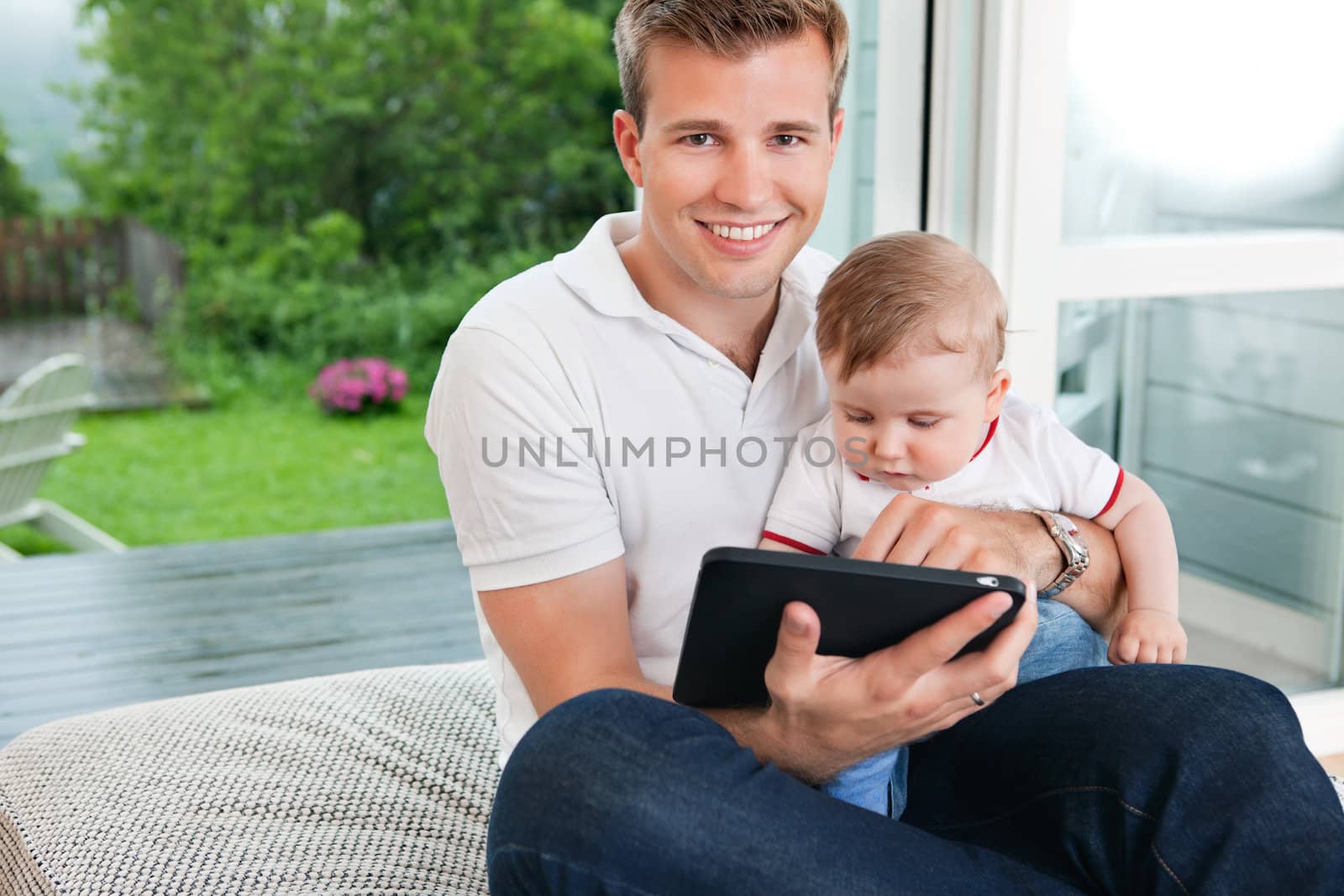 Man using digital tablet with child by leaf