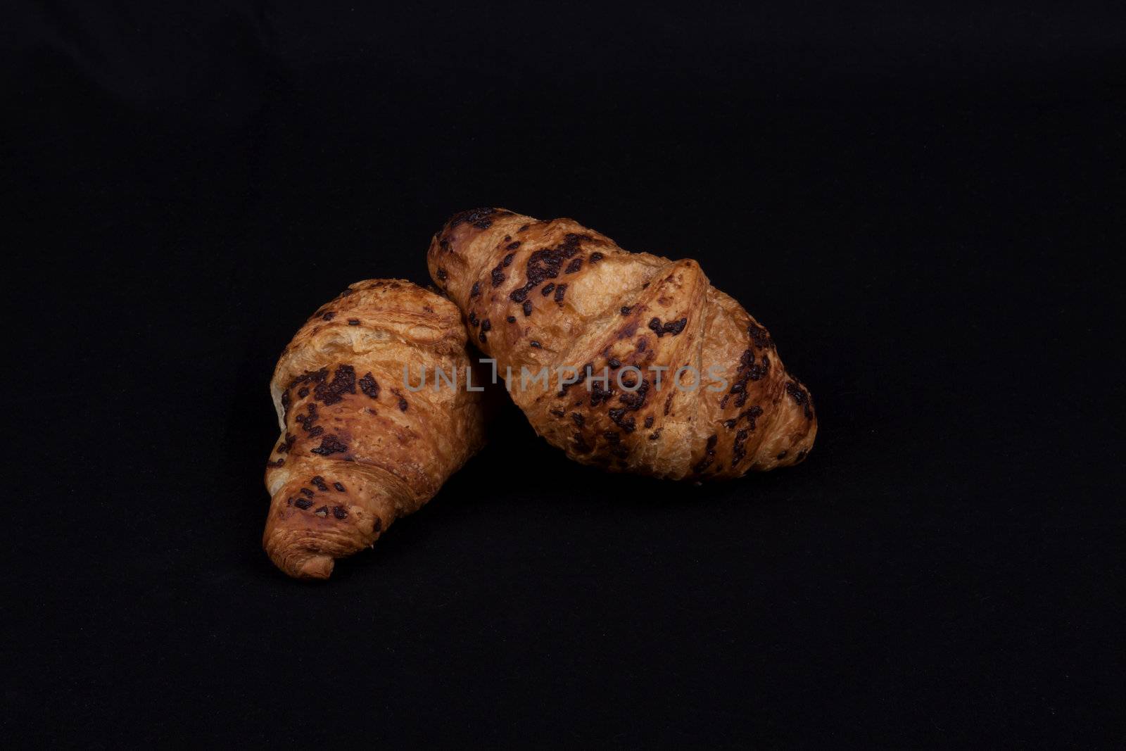 fresh chocolate croissant isolated on a black background