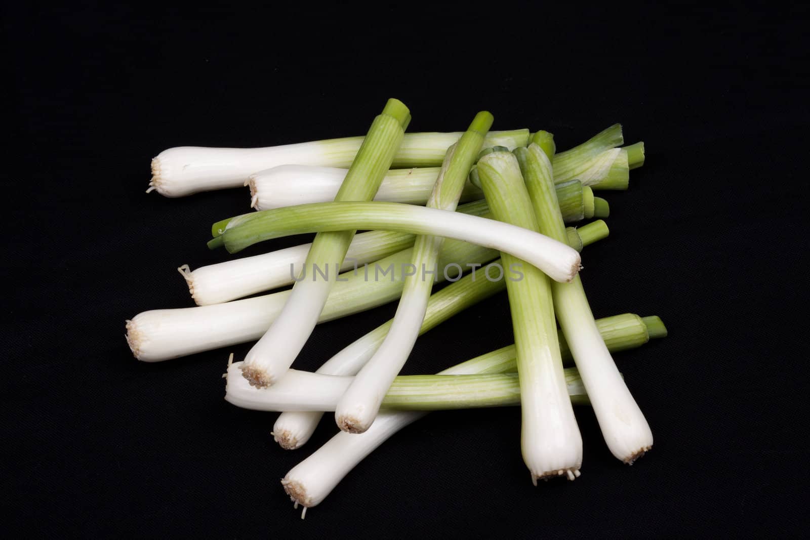 Fresh baby  leek on isolated on a black background