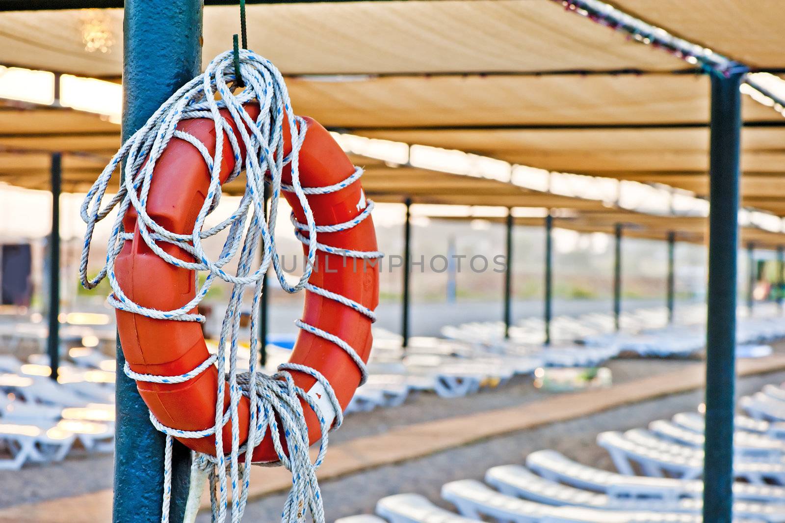 Lifebuoy hanging on a pole on the public beach by kosmsos111