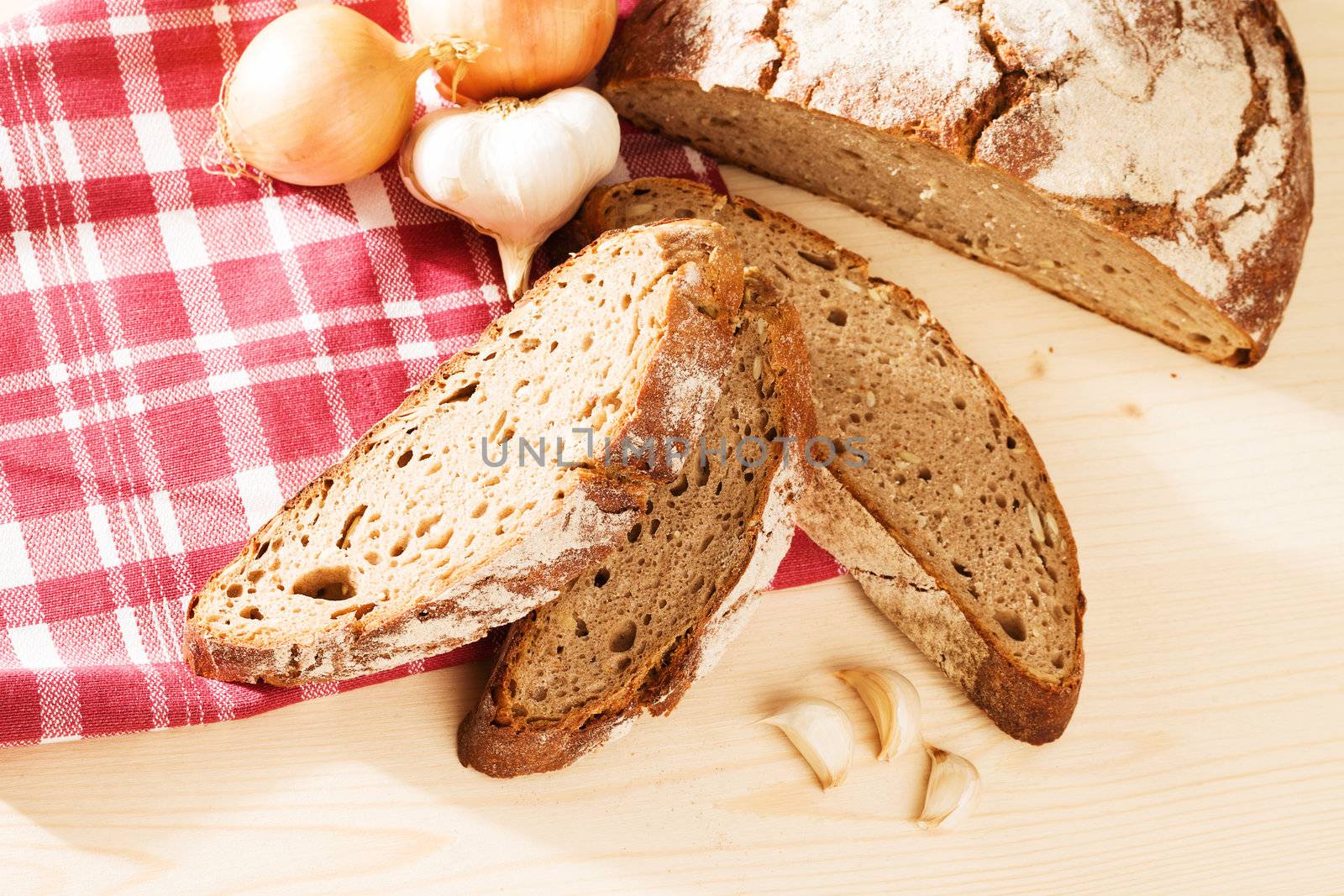 rustic bread with garlic and onions and a towel from top on wooden background