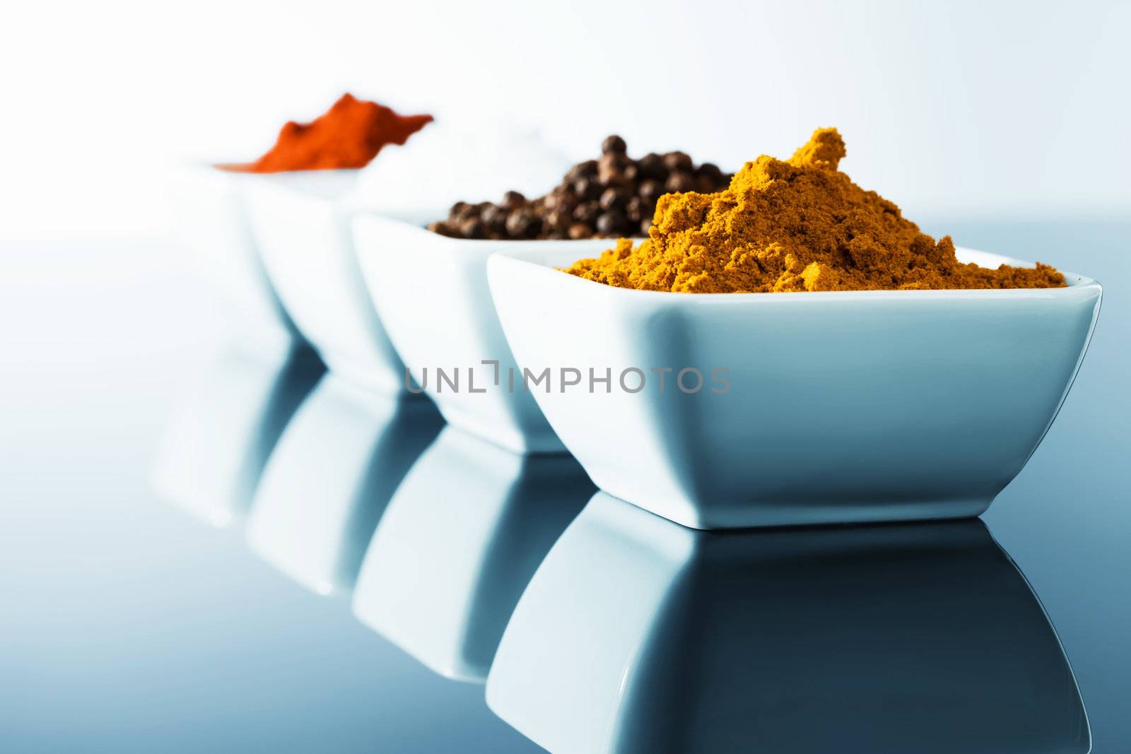 spices in small bowls in row with blue light