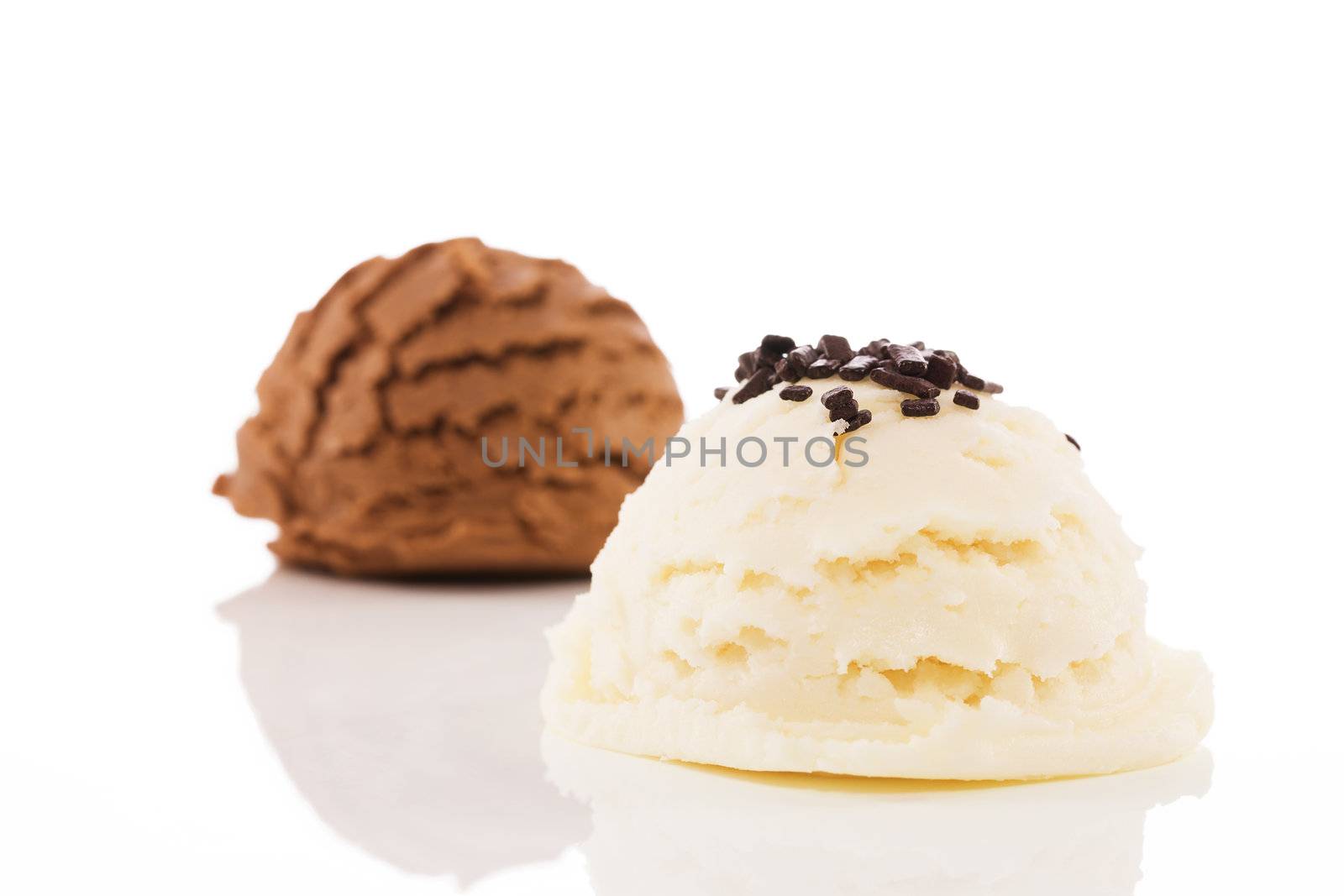 scoop of vanilla flavor ice cream with chocolate crumbles in front of a scoop chocolate ice cream on white background