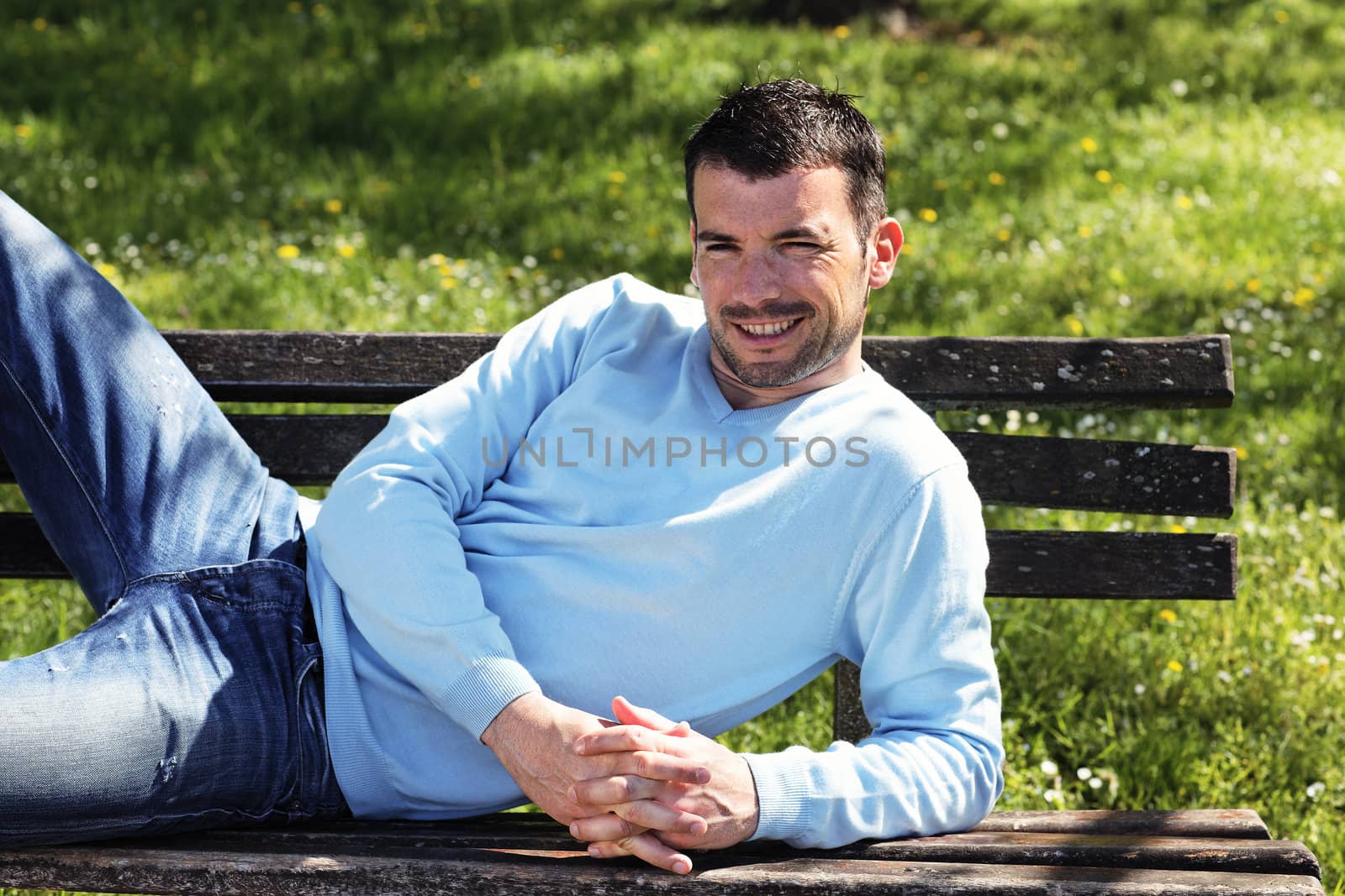 relaxed man on  a bench in a park in spring