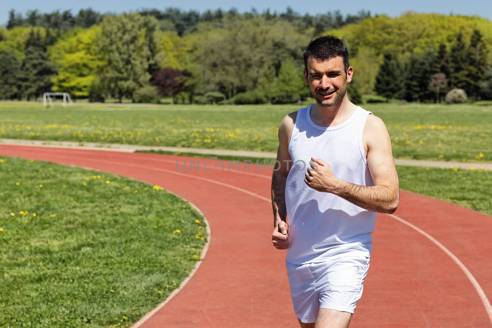 man running on a track in spring