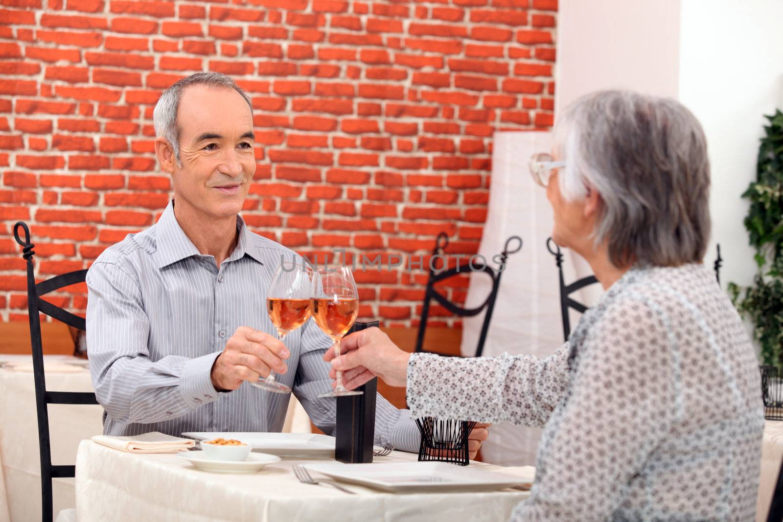 Elderly couple eating in restaurant by phovoir