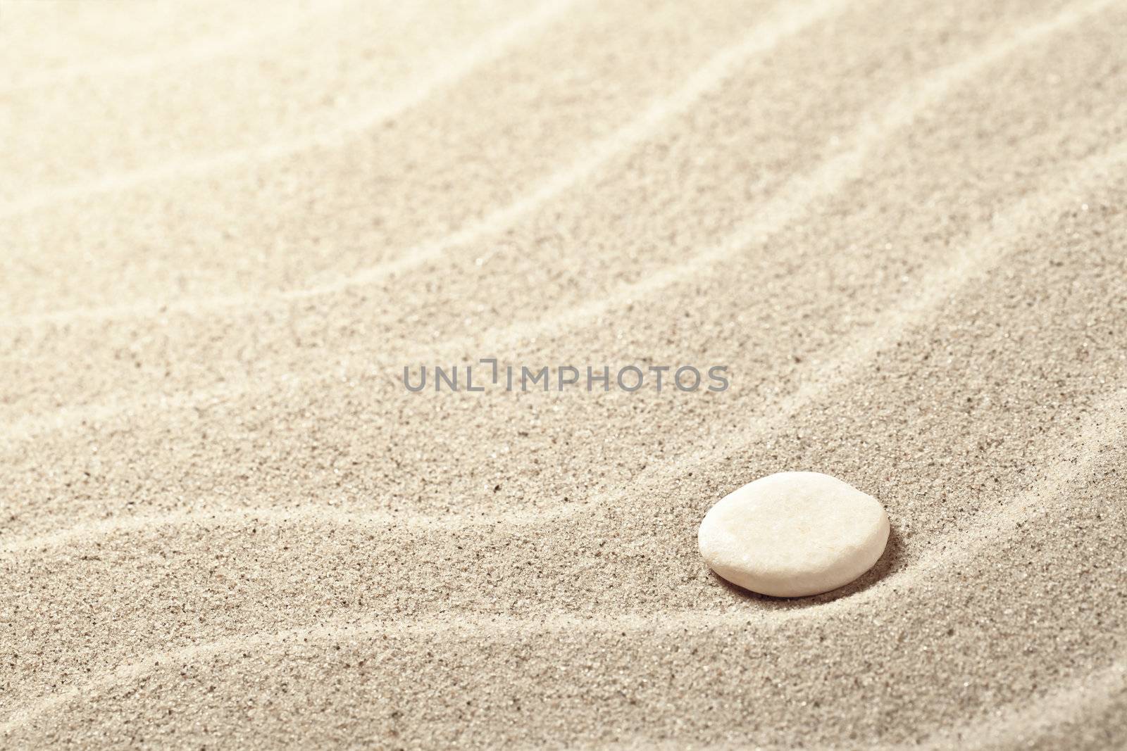 Sand background with white stone. Sandy beach texture