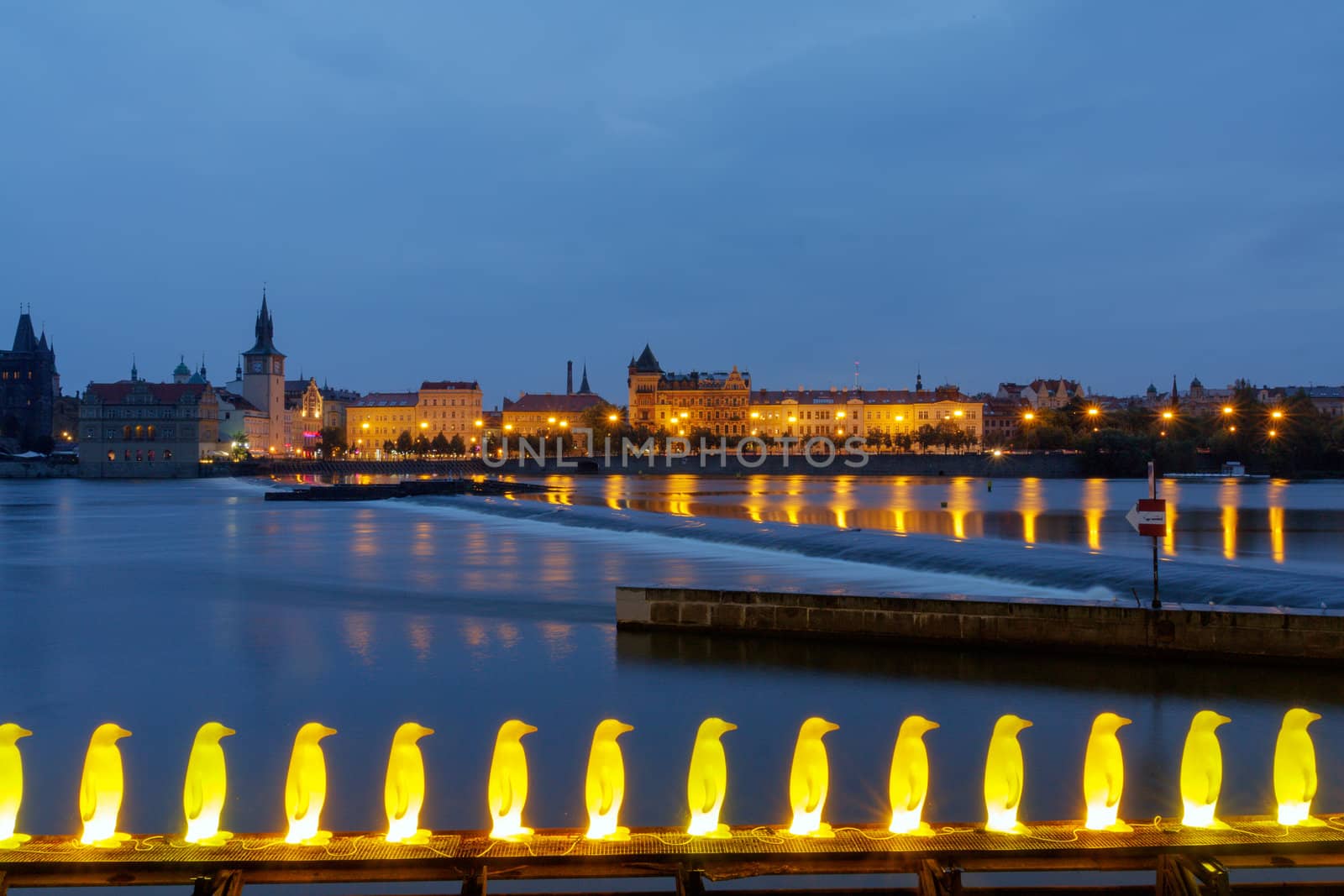 Smetana embankment in Prague with city houses at night illumination.