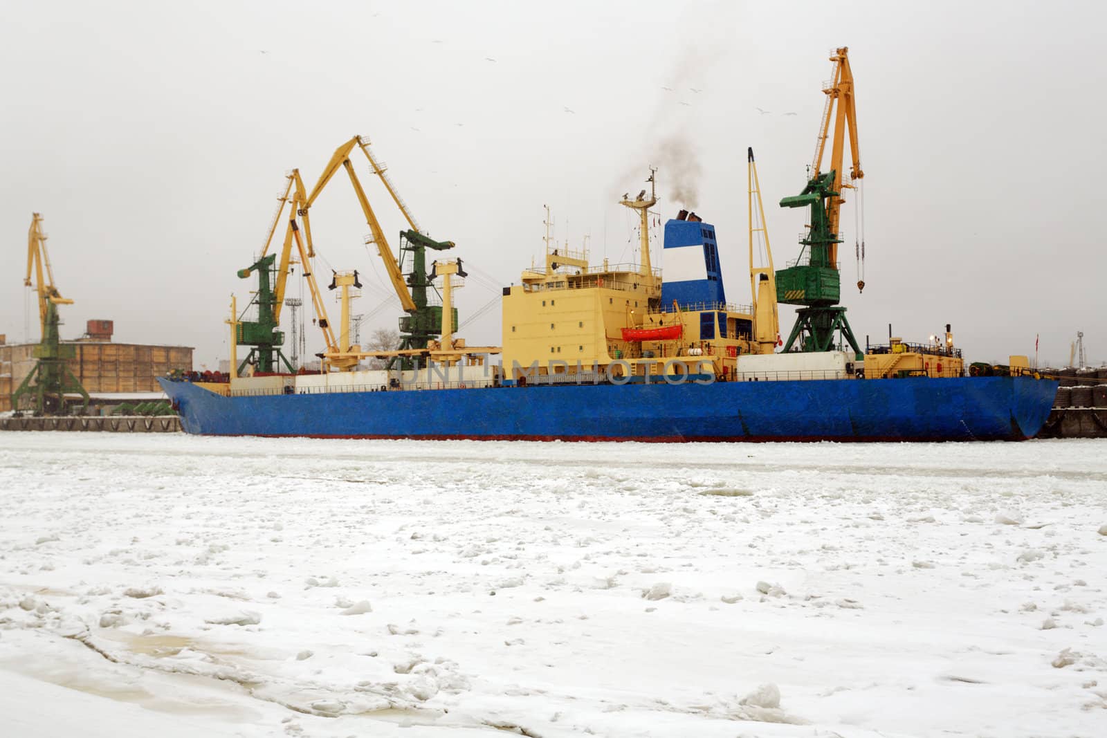 Cranes unloading a ship in a harbor