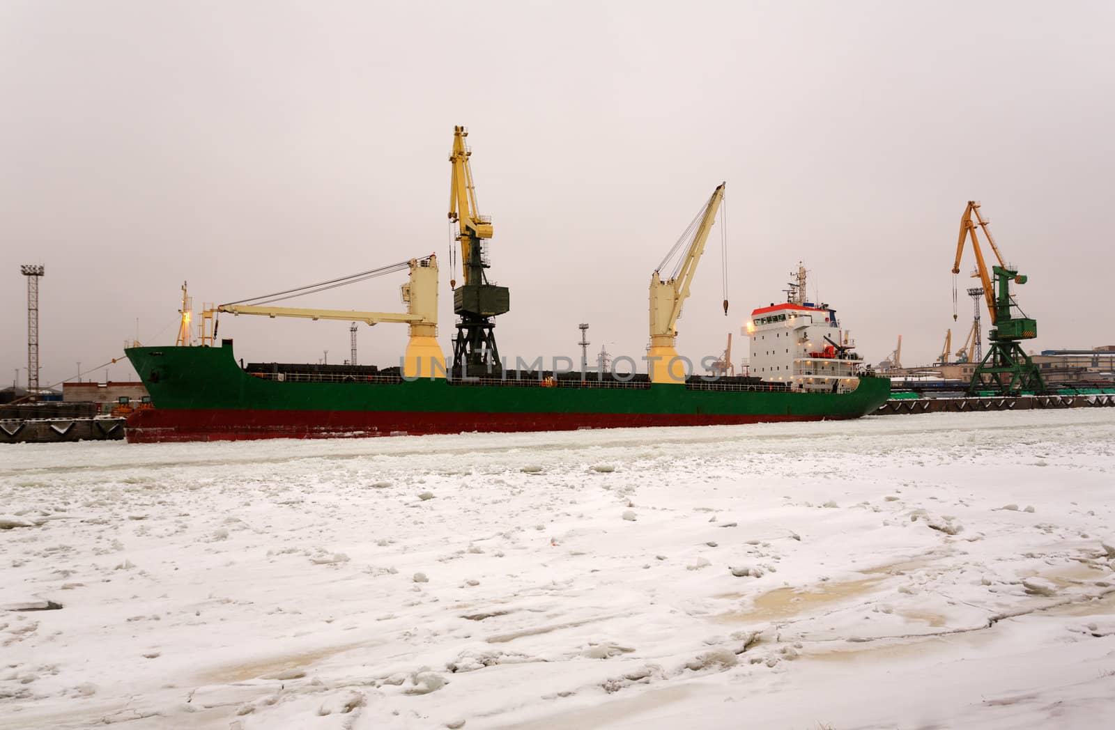 Cranes unloading a ship in a harbor