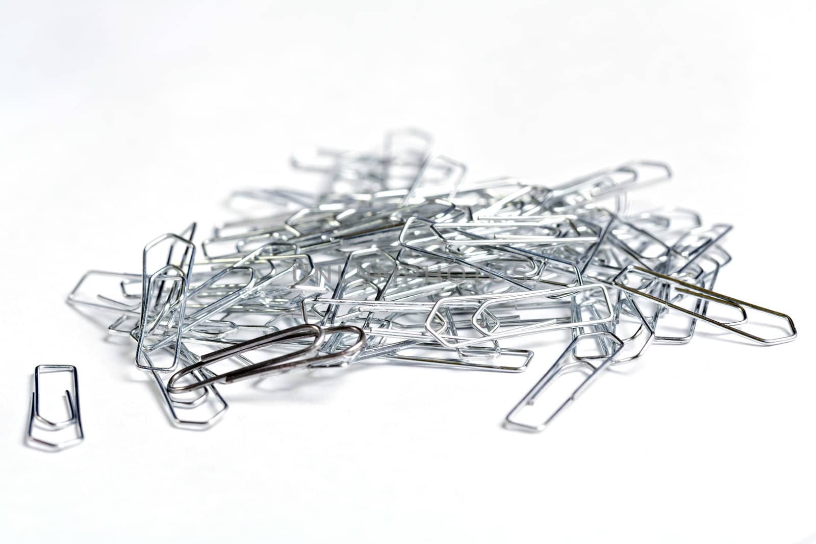 Bunch of metallic paper-clips on white background