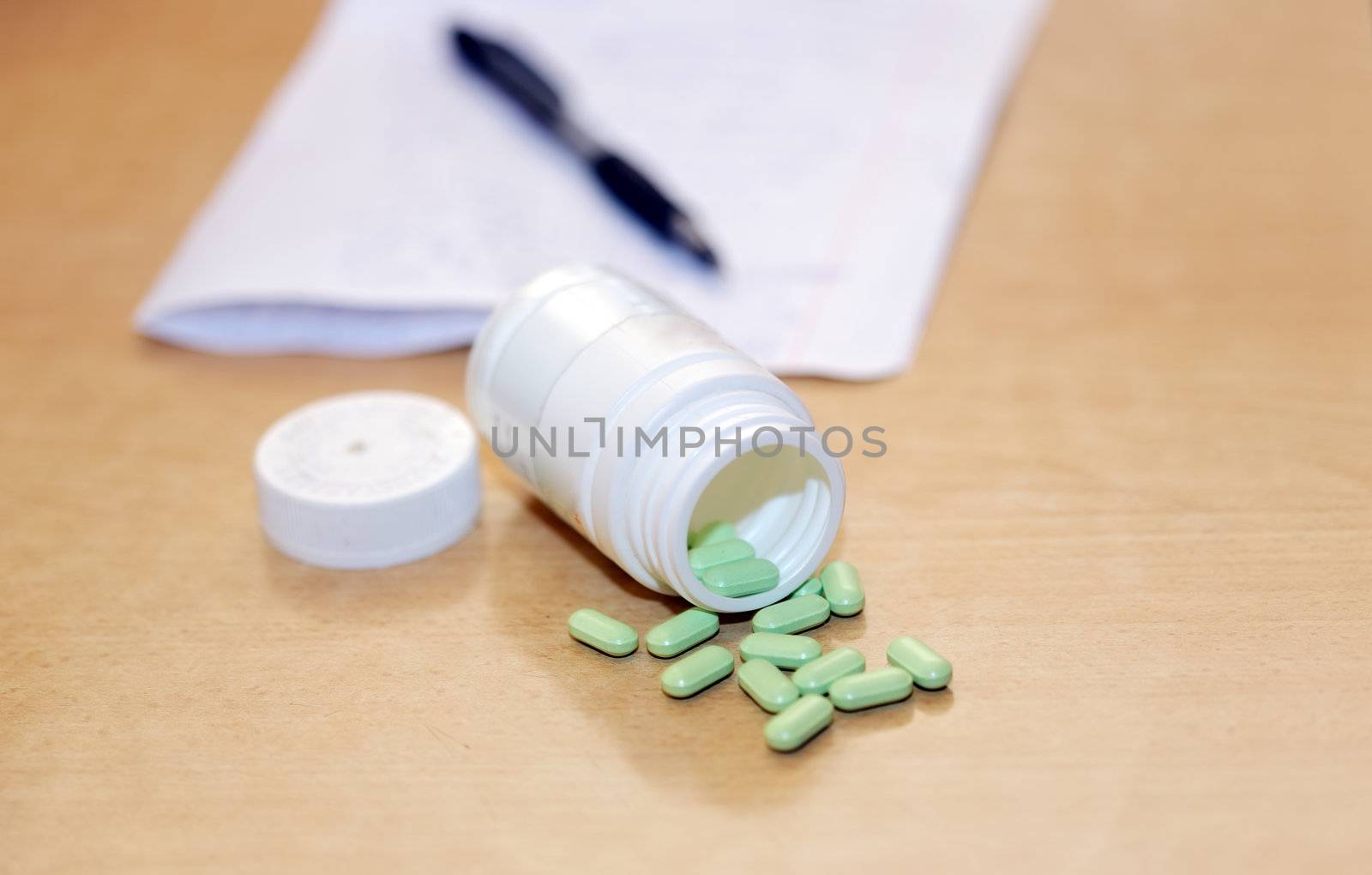 Medicine bottle and pills and note with a pen