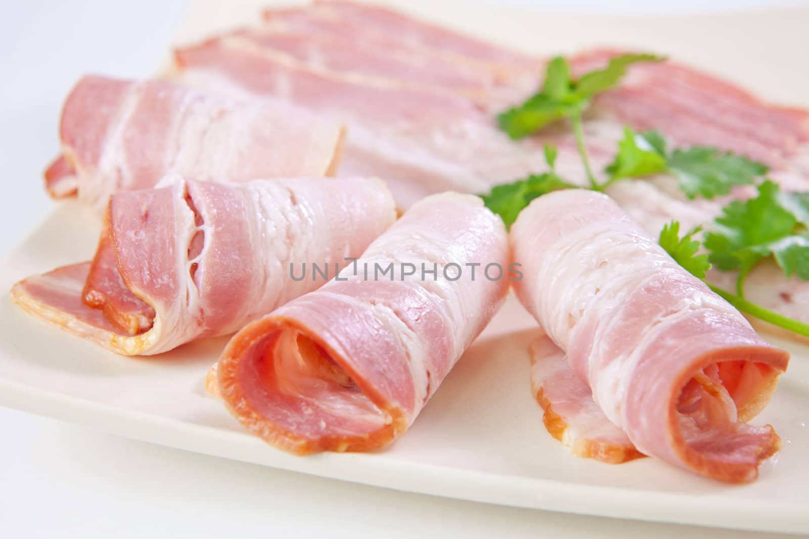 Tasty sliced bacon with vegetables isolated on white background