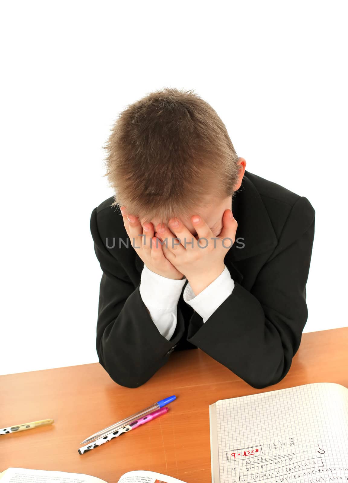 sad and tired schoolboy in the classroom