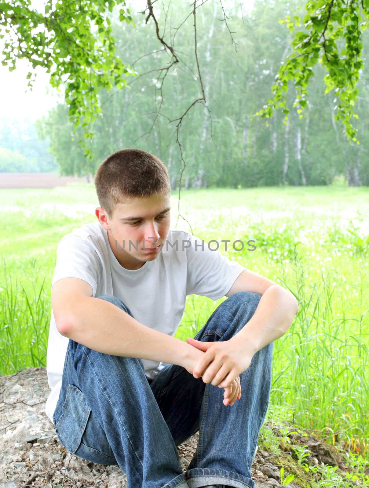 sad teenager sitting in the forest alone