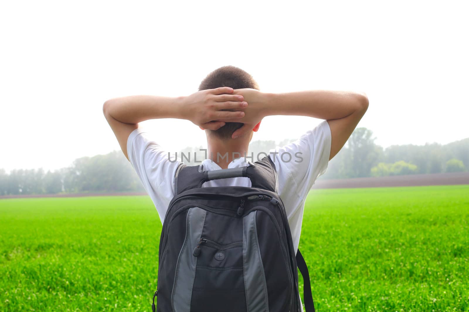 teenager with knapsack in the summer field