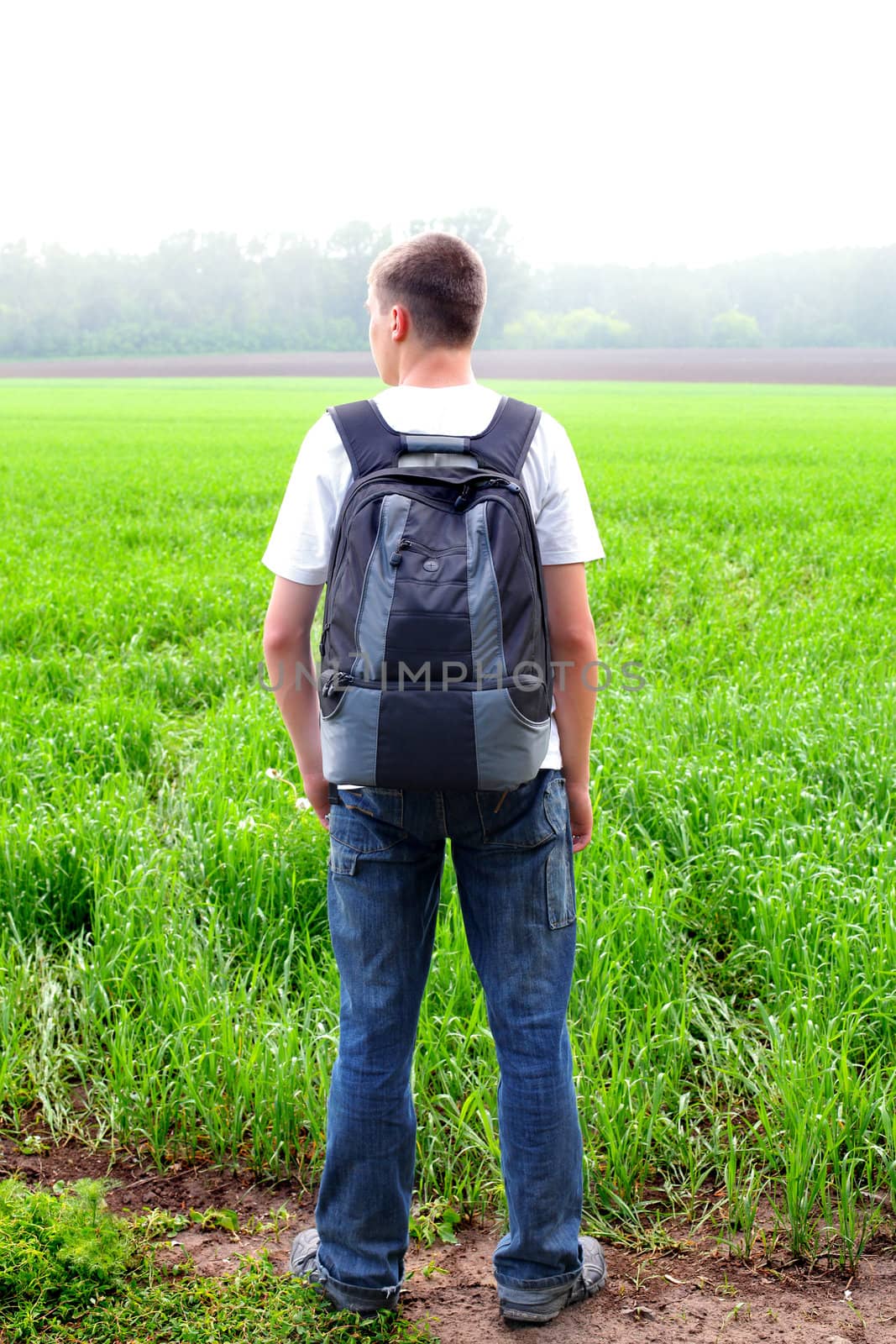 teenager with knapsack in the summer field