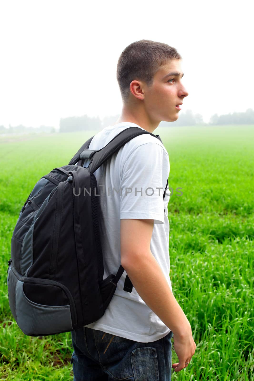 teenager with knapsack in the summer field