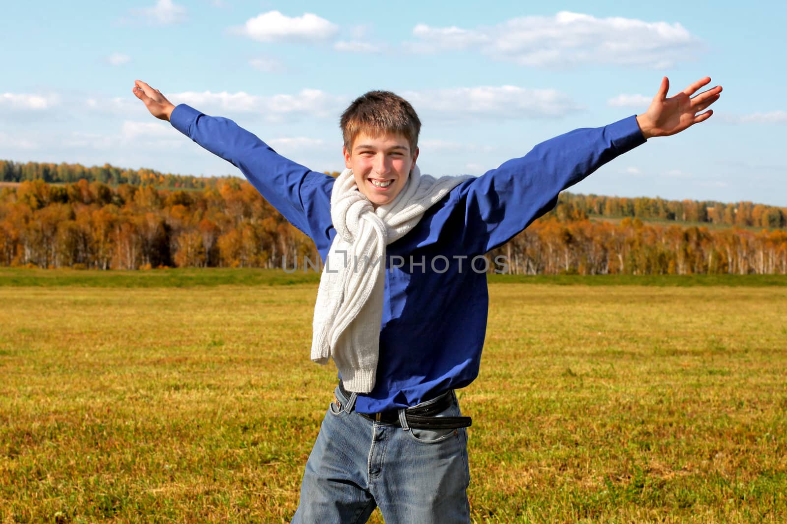 happy teenager with hands up in the autumn field