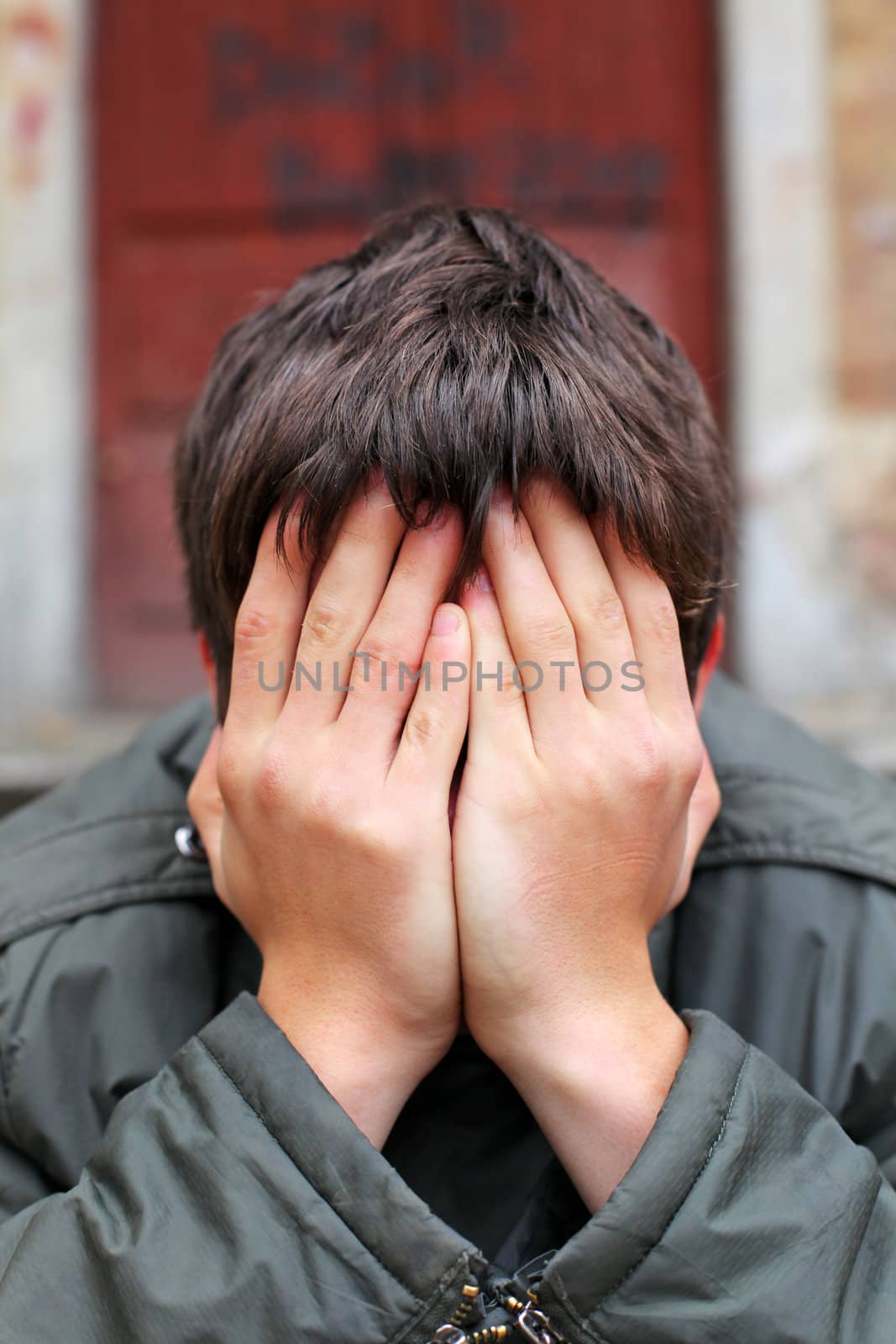 man with hidden face on the old house background