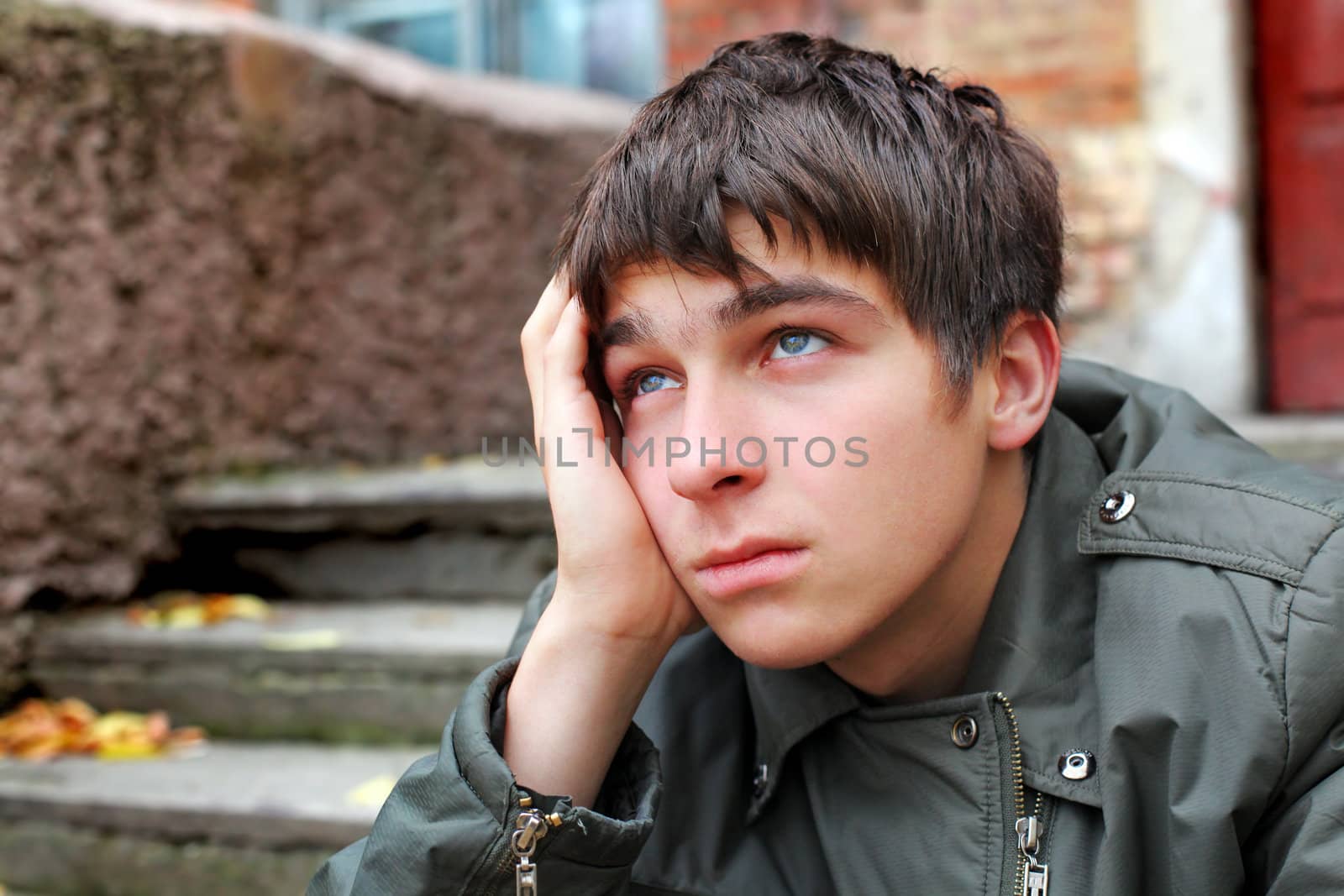 sad young man portrait on the old house background