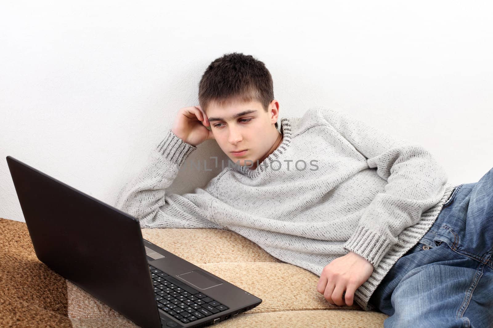 young man with notebook on sofa