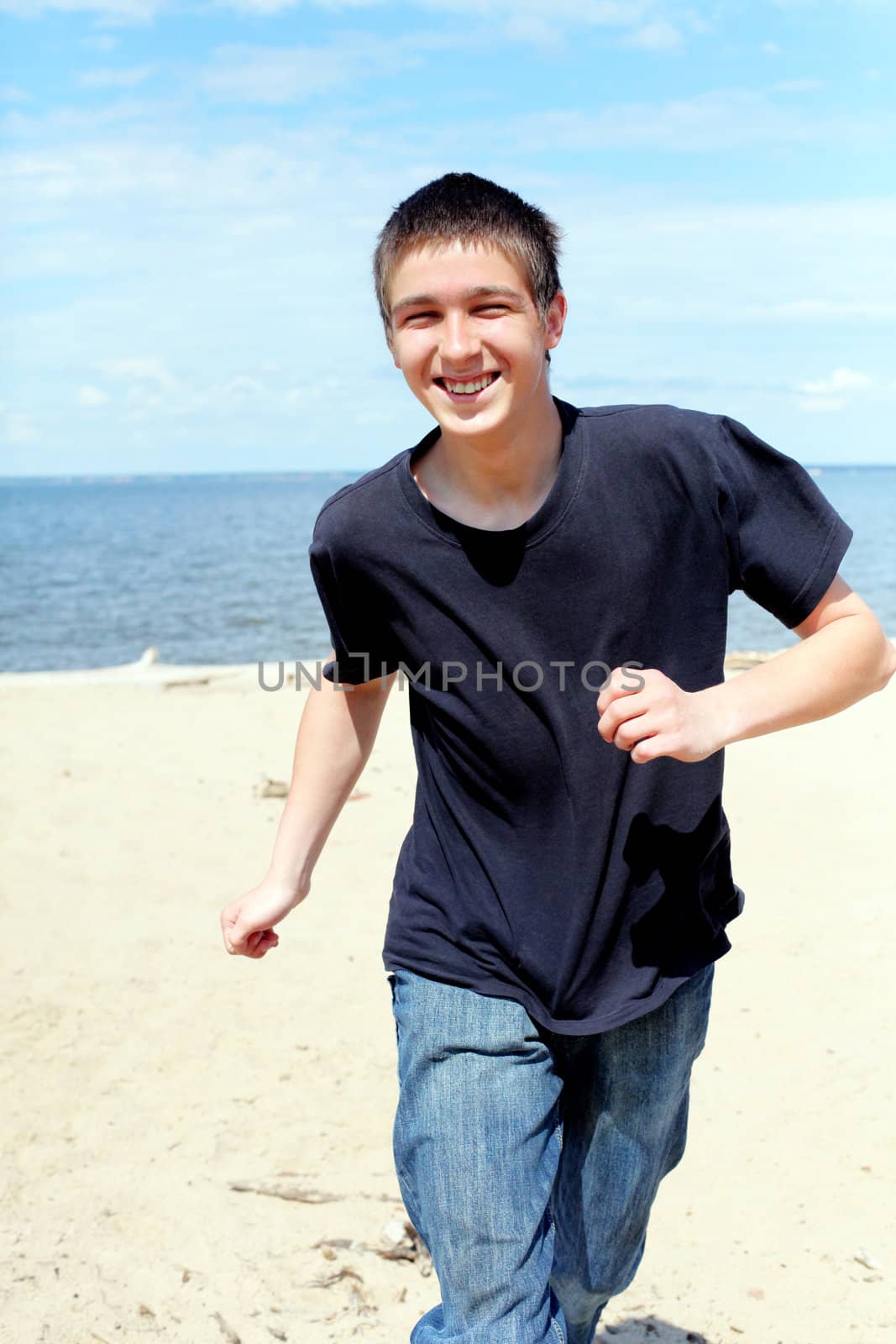 happy teenager running on the beach