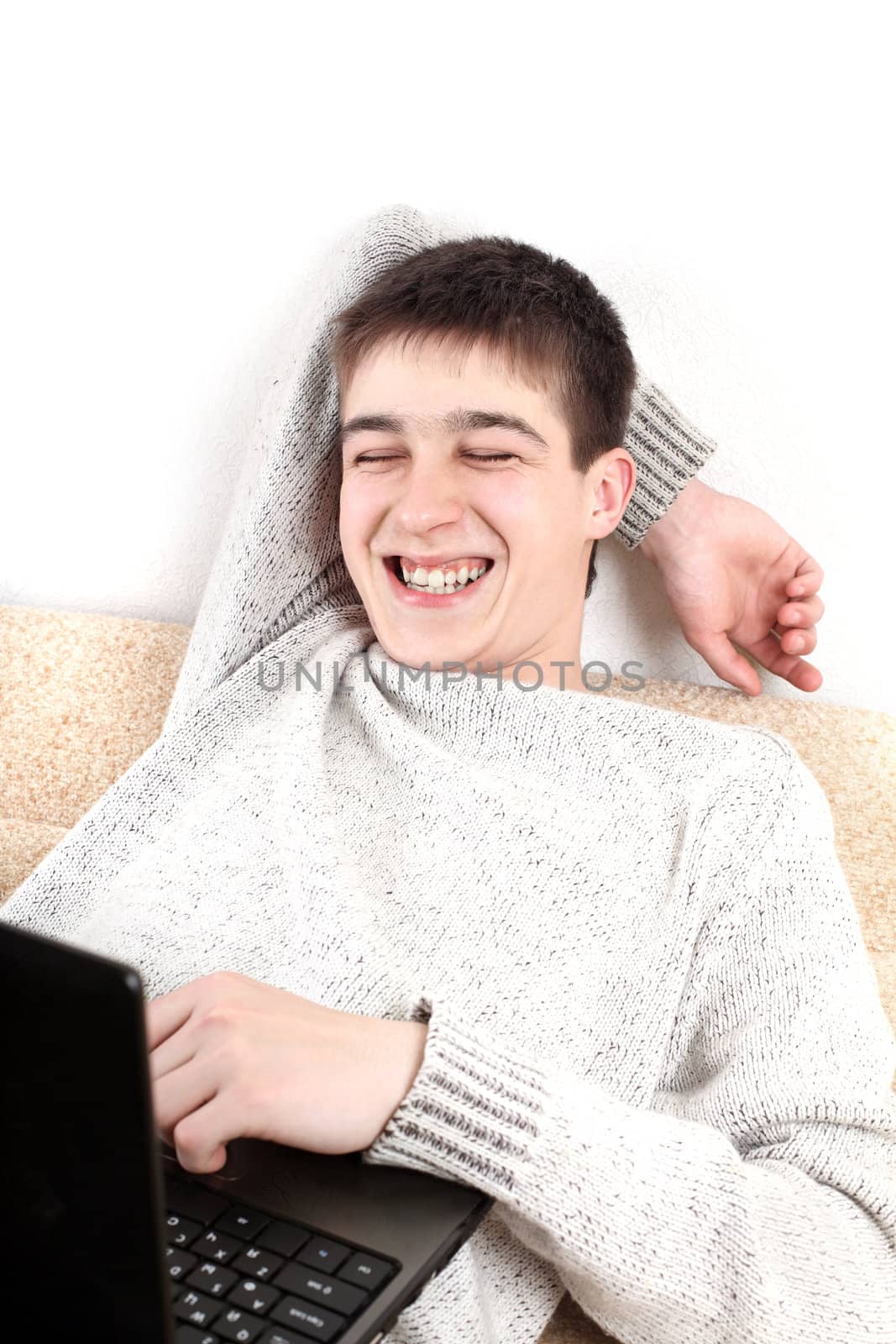 happy young man with notebook on sofa