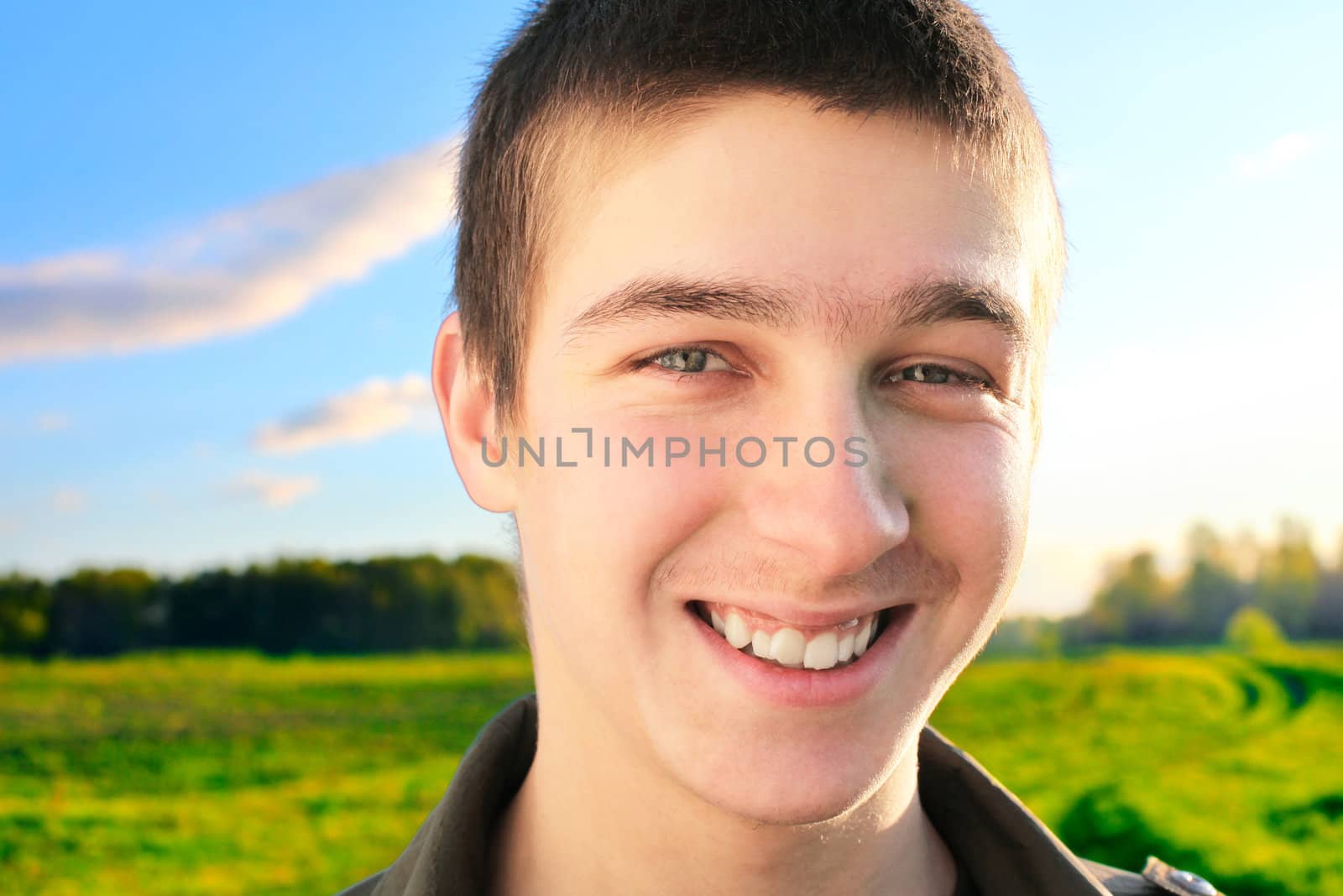 happy young man portrait in the summer field