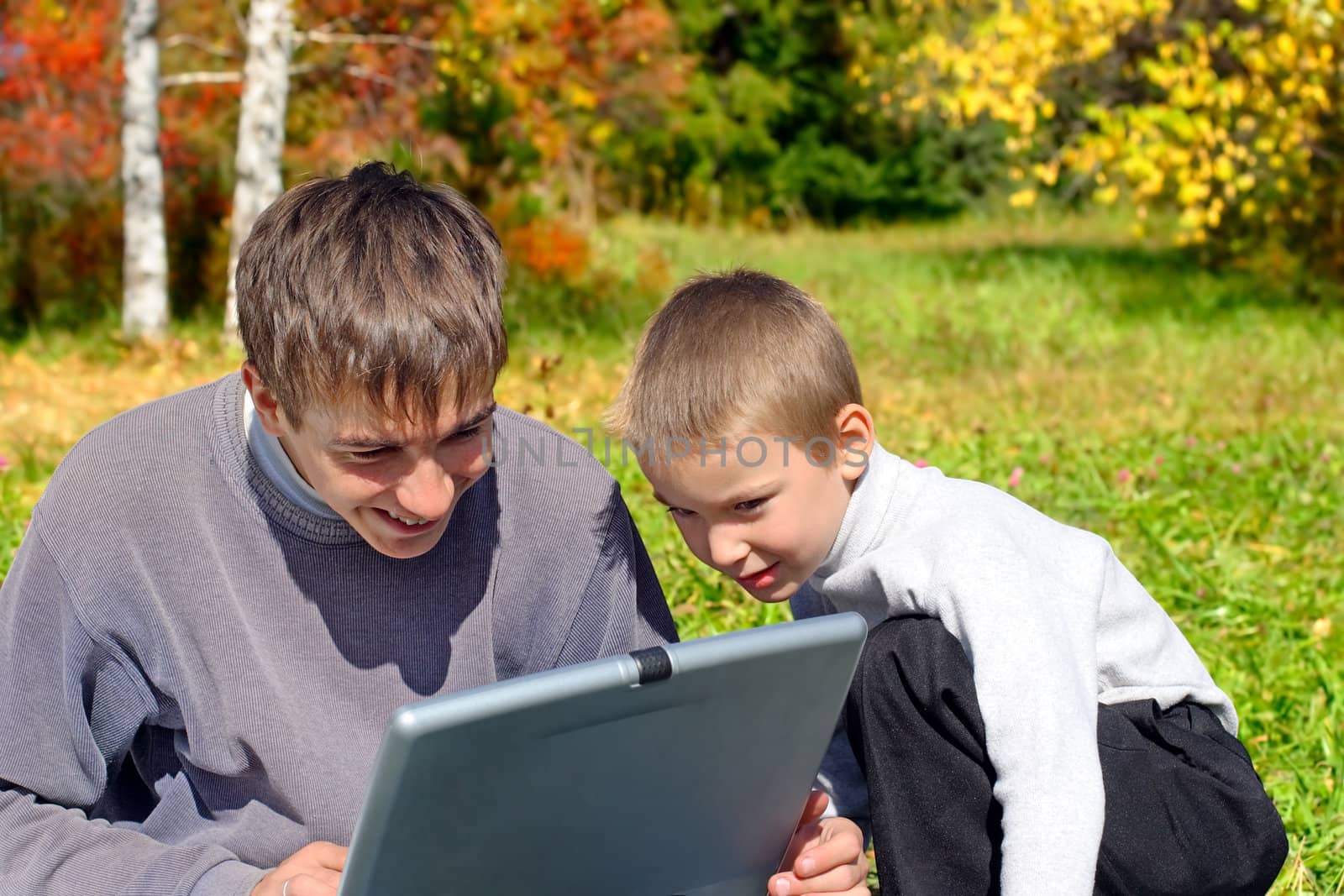 cheerful teenager and kid with notebook outdoor