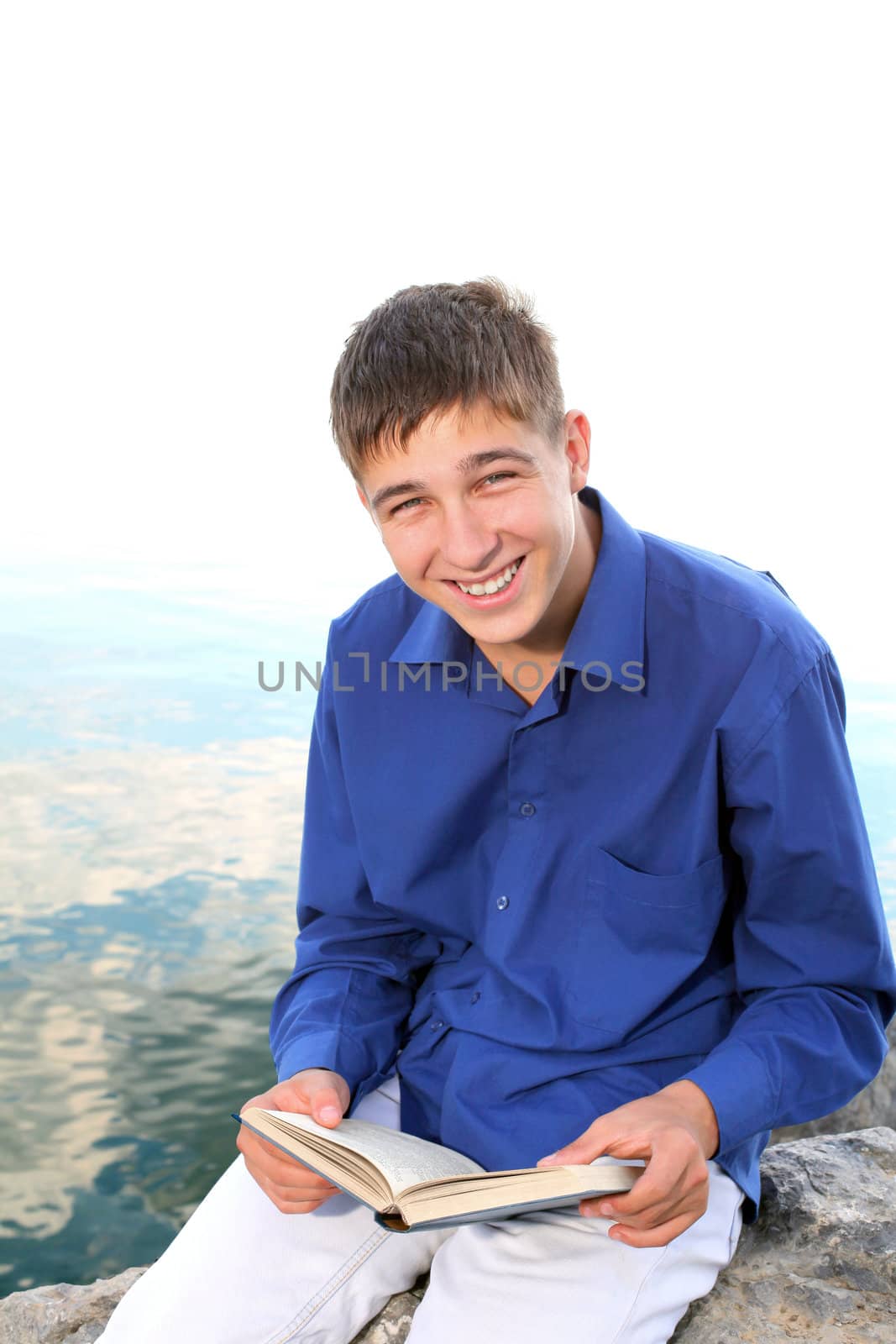 smiling teenager with a book near the water outdoor