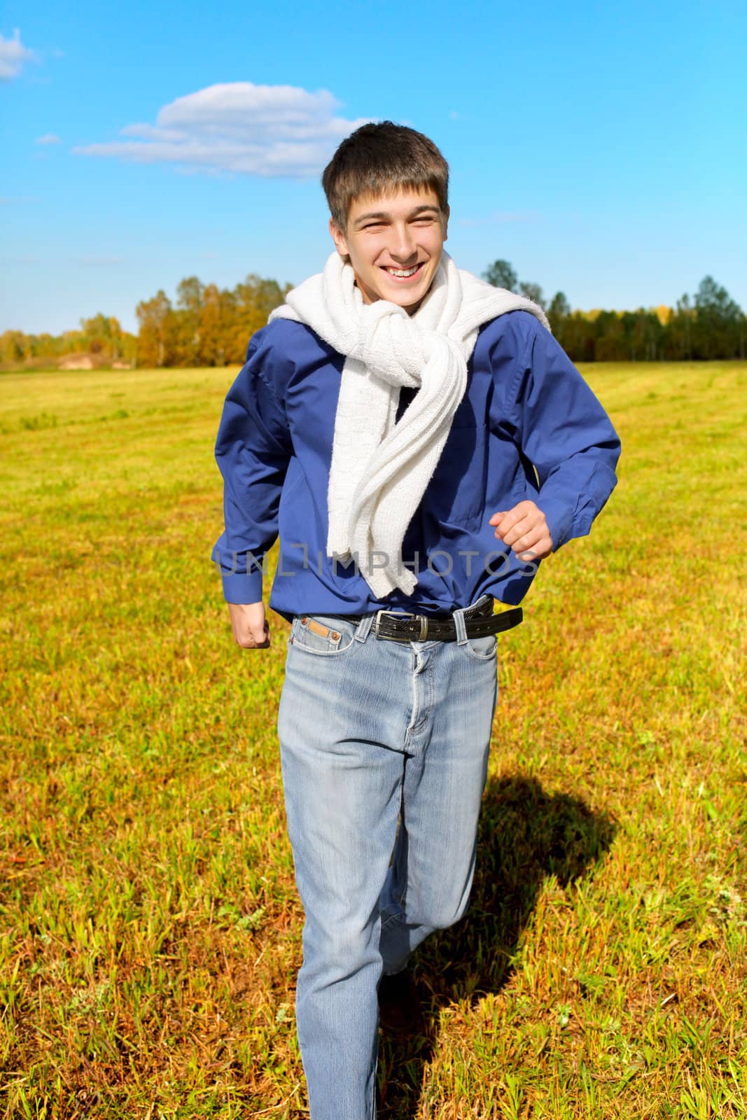 happy teenager running on the autumn field