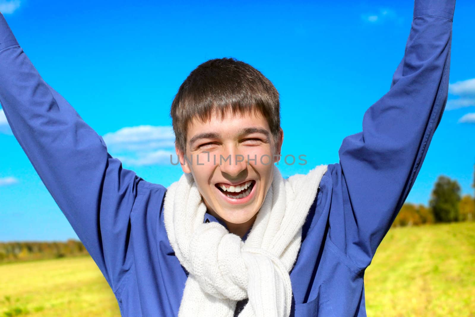 happy young man on autumn field rising up his hands