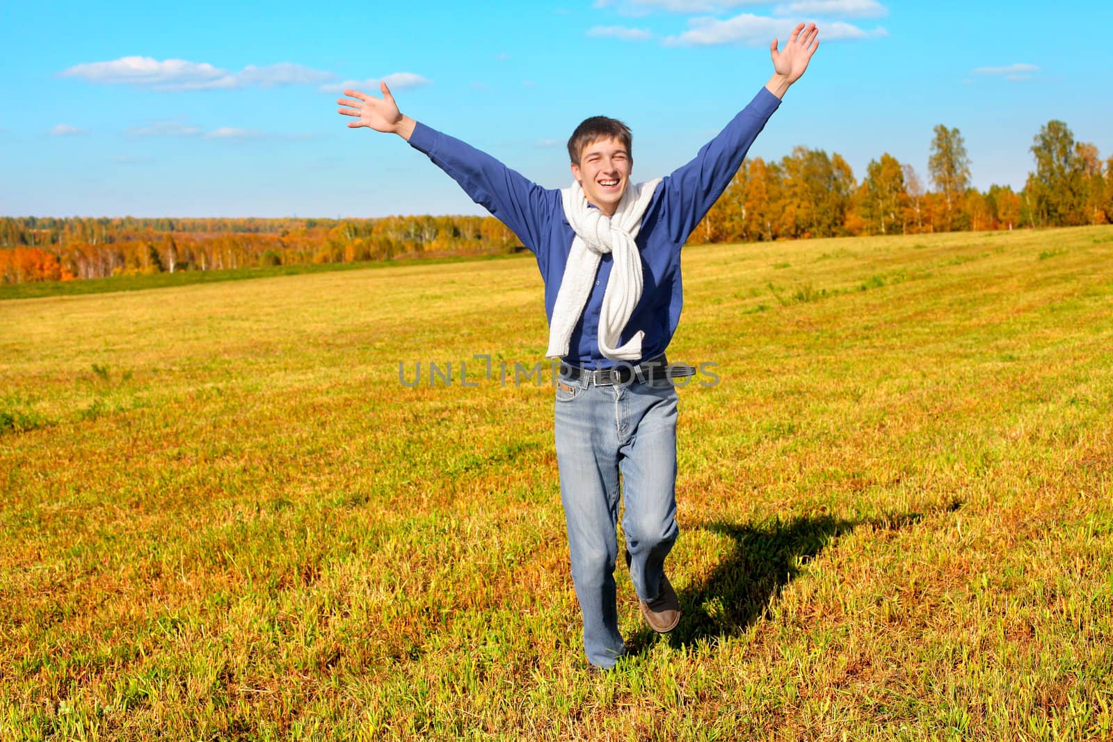 happy teenager with hands up in the autumn field