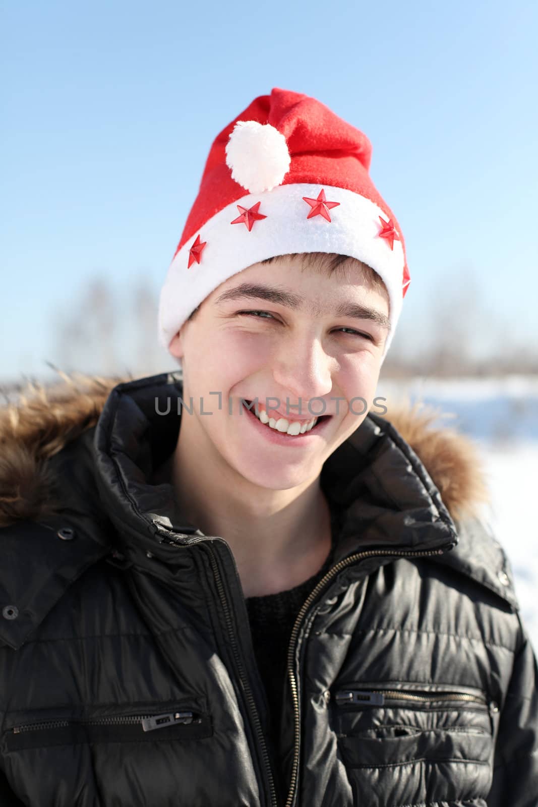 happy young man in santa's hat outdoor in the winter