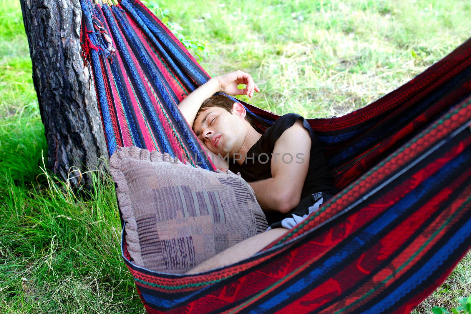 Young Man sleeping in the Hammock on the Nature