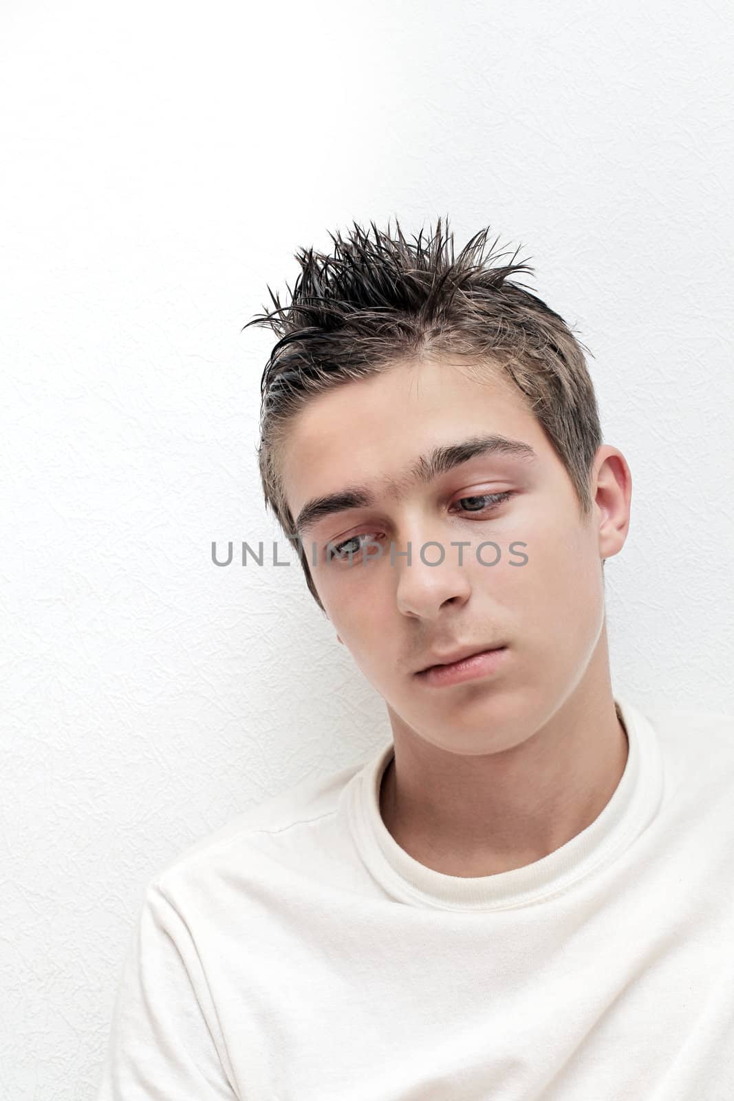 Sad Young Man portrait on the White Wall background