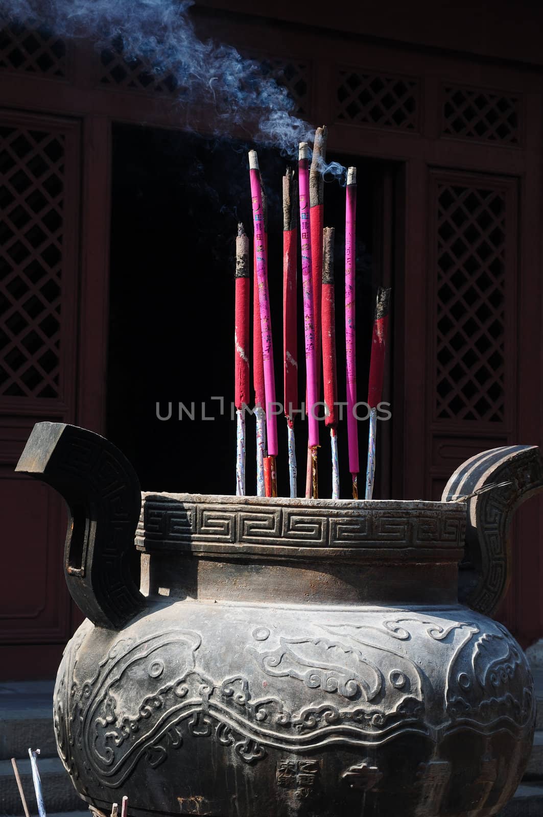 Burning incense sticks in front of a traditional Chinese ancient temple