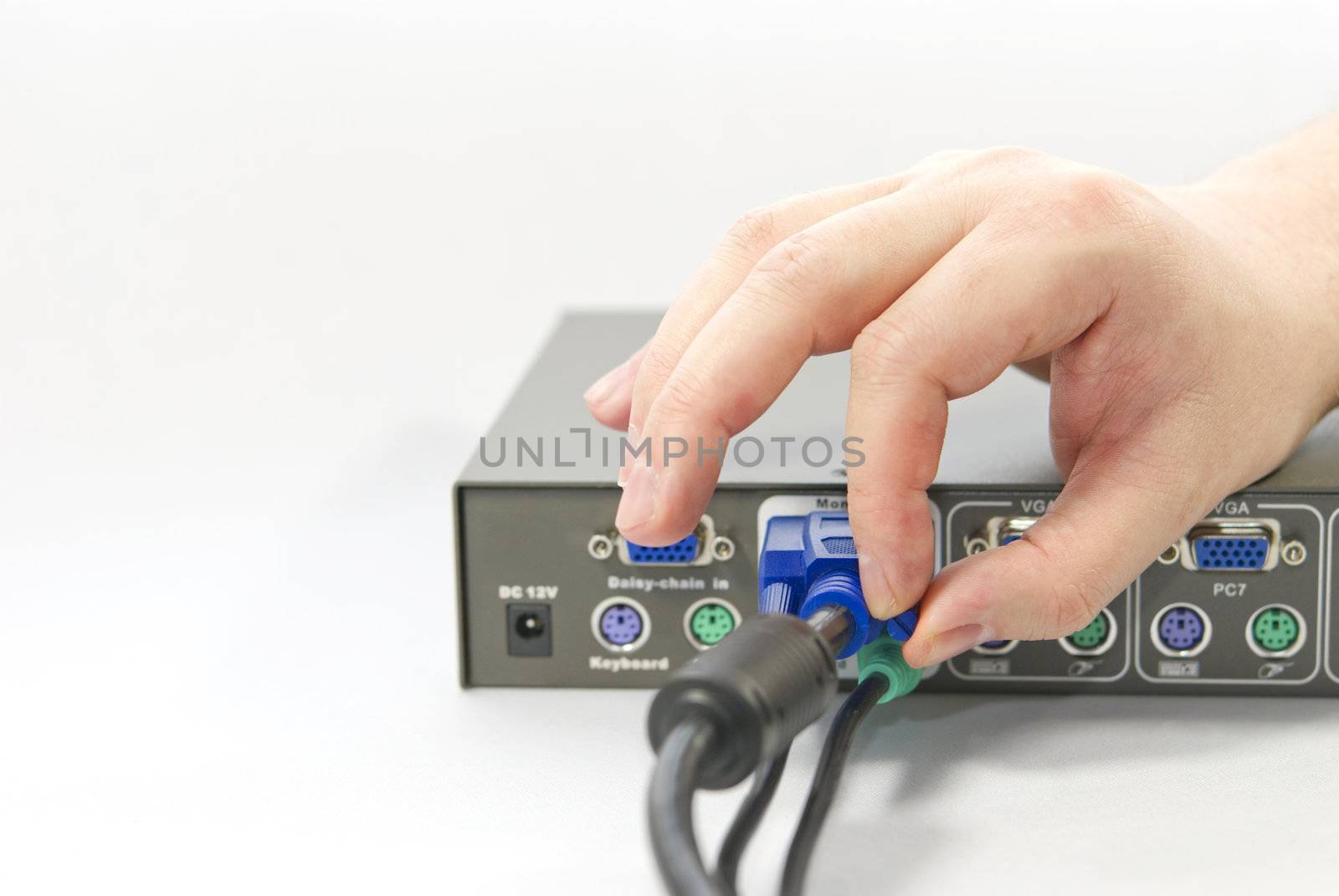 KVM (keyboard, video and mouse) switch and a human hand with an VGA (Video Graphics Array) connector on white background