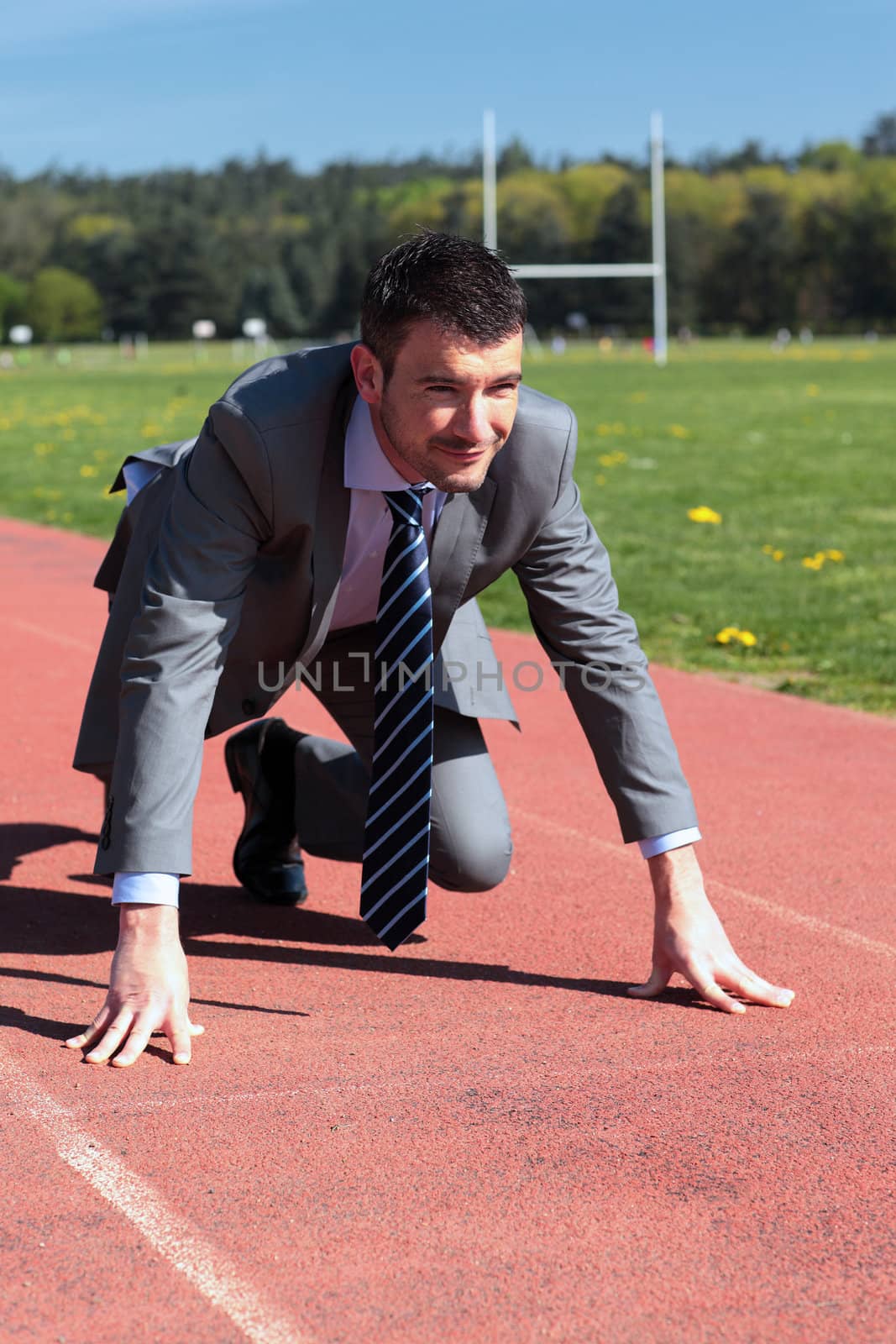 young businessman on running track in summer