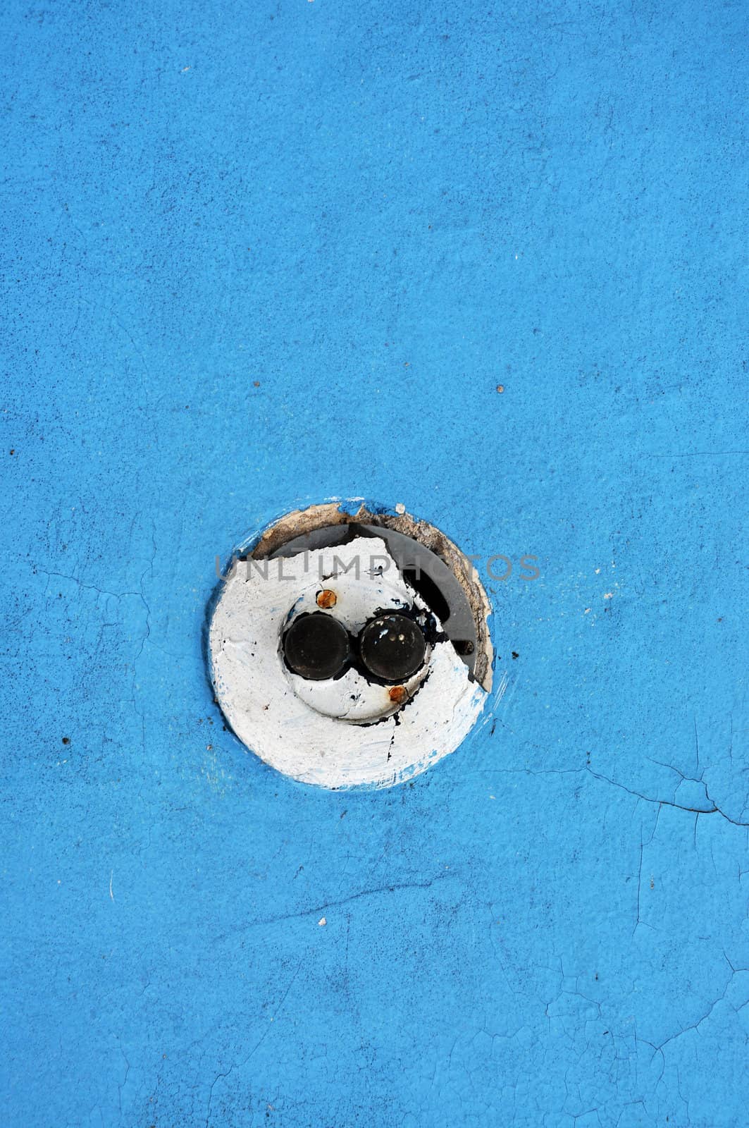 Round vintage light switch on blue wall