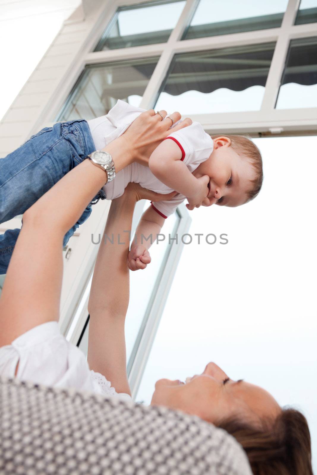 Young cheerful mother playing with cute child