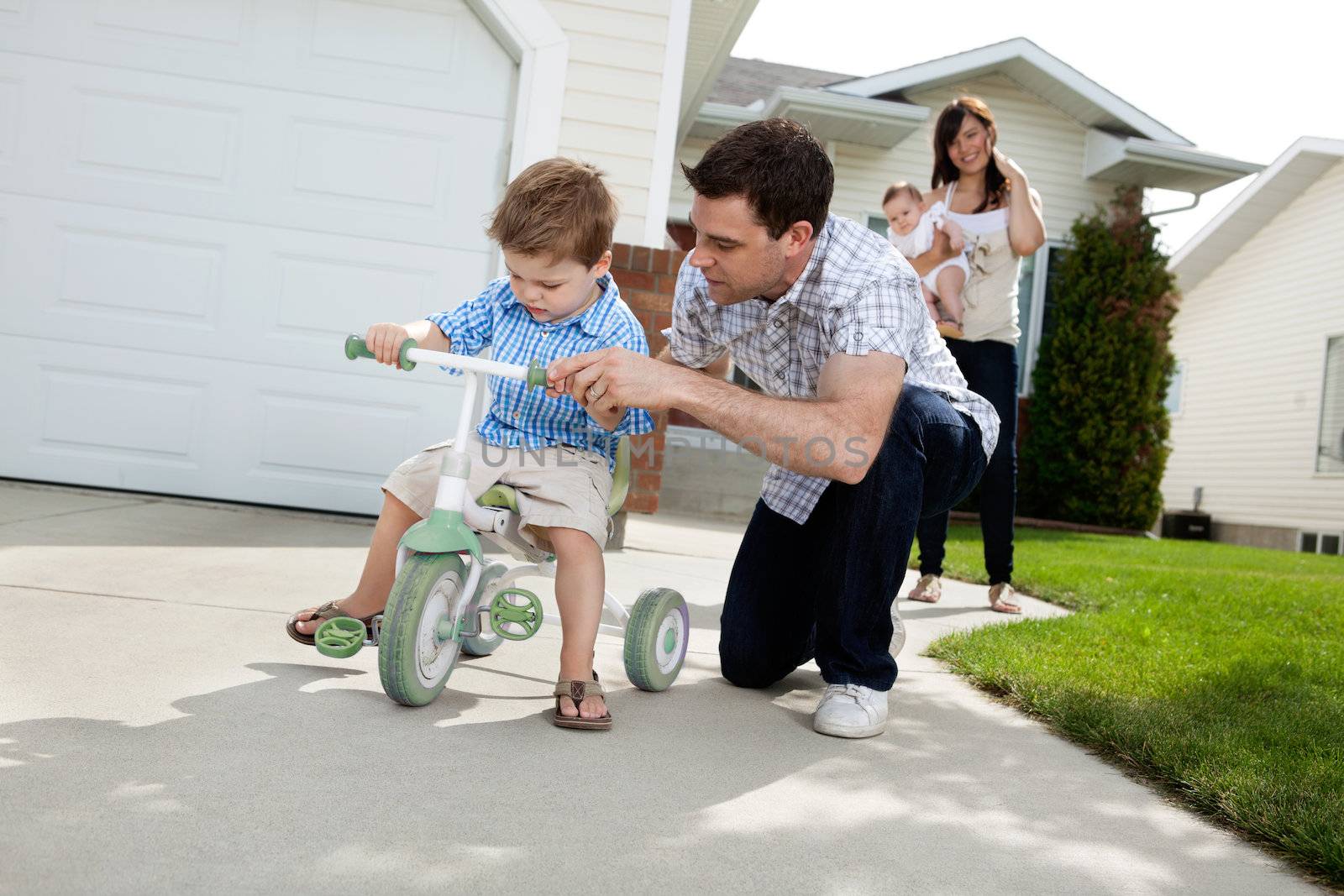 Father Teaching Son To Ride Tricycle by leaf
