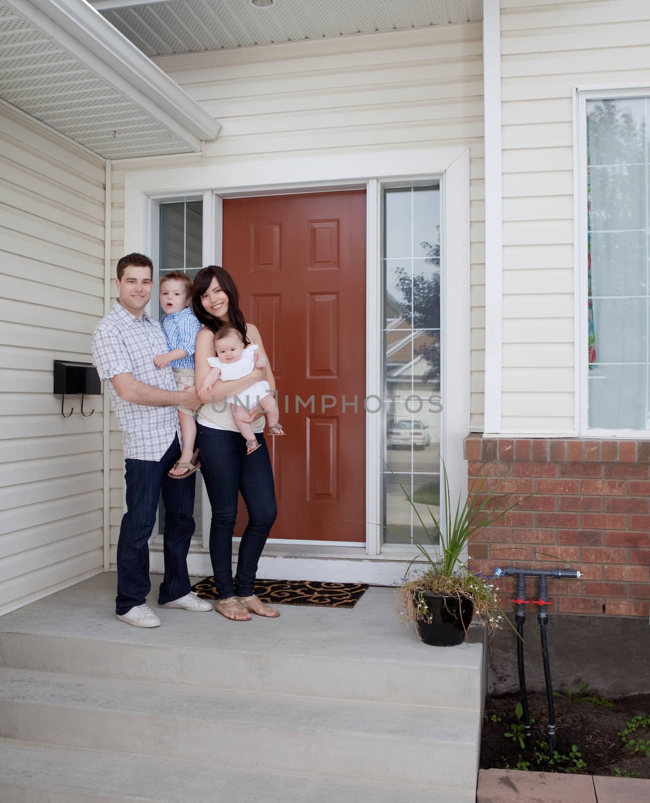 Young Family in Front of House by leaf