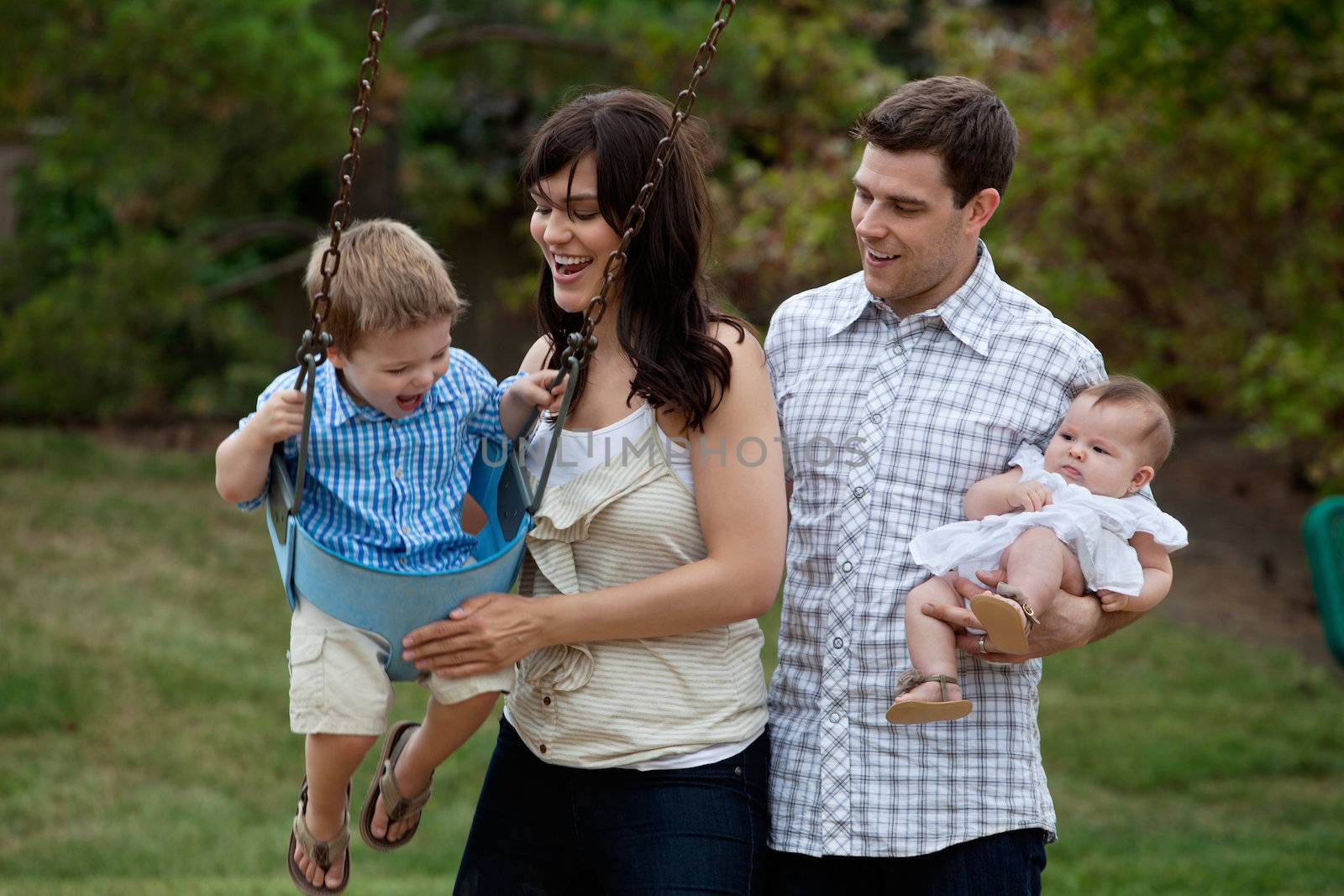 Happy family of four having fun in playground