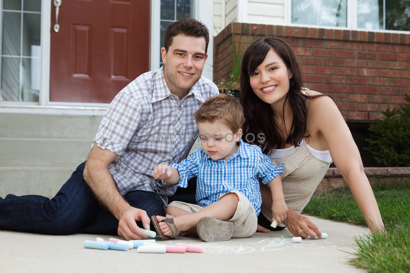 Portrait of happy family playing outside house on sidewalk