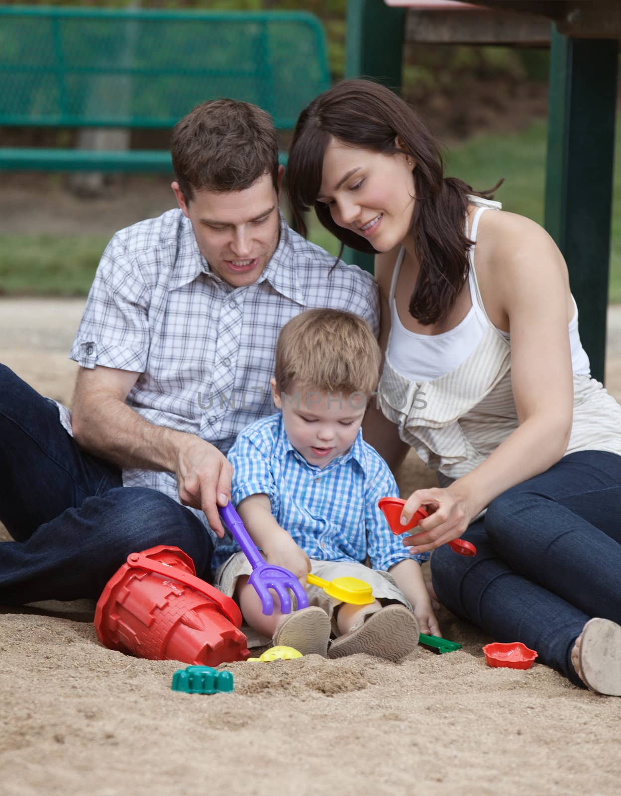 Young couple playing with their son in playground